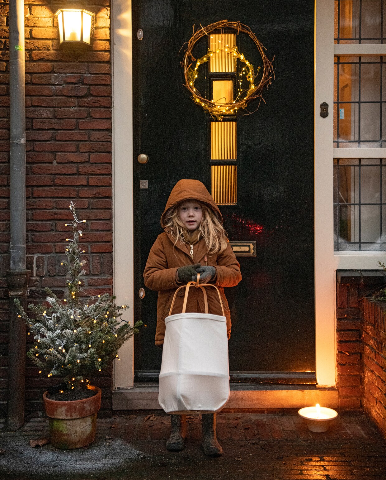 Lev staat op de stoep, klaar om de lampion op te hangen. vtwonen 13-2022 | productie Insidehomepage | styling Myla Griese | fotografie Louis Lemaire