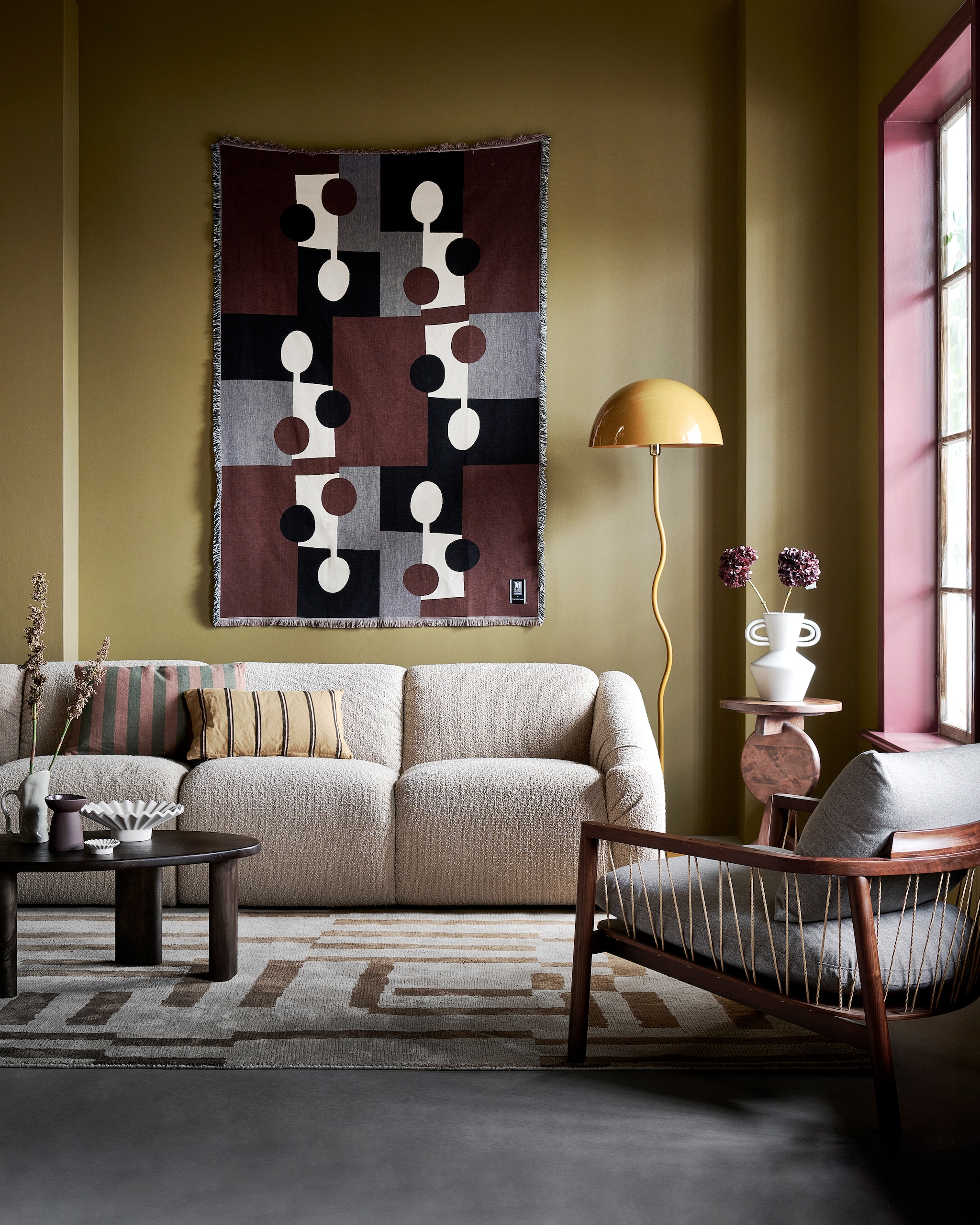 4-zitsbank Cooper, 300x97x72 cm (bxhxd) € 2195,-, metalen vloerlamp Salsa € 149,95, vloerkleed Cato, katoen en polyester, 200x300 cm € 300,- (loods5.nl). Katoenen deken aan de wand Lia van Markslöjd, 130x170 cm € 99,-, mangohouten salontafel 54,8x98,1x34,8 cm (bxdxh) € 329,-, roestbruine keramieken kandelaar € 14,99, witte terracotta vaas, 21,7x30 cm (bxh) € 34,99, keramieken schaal € 34,99, waxinelichthouder € 5,99 (hm.com). Keramieken kan Razan € 29,90 (bloomingville.com). Geel kussen € 14,99 (karwei.nl). Kussen Linen Stripe van By Fonq, katoen en linnen € 34,99 (vtwonen.nl/shop). Fauteuil Enzo in Fabio Stone, walnoothouten frame met polyester bekleding, 71x80x75 cm (bxdxh) € 529,- (sofacompany.com). Mangohouten bijzettafel Nori van Woood, 40x60 cm (Øxh) € 129,- (basiclabel.nl). Muurverf Scented Cumin No. 34 en verf kozijn Merlot Mania No. 123 van Lab Paint, 1 liter € 51,- (vestingh.nl). vtwonen 01-2024 | styling Kim van Rossenberg | fotografie Sjoerd Eickmans