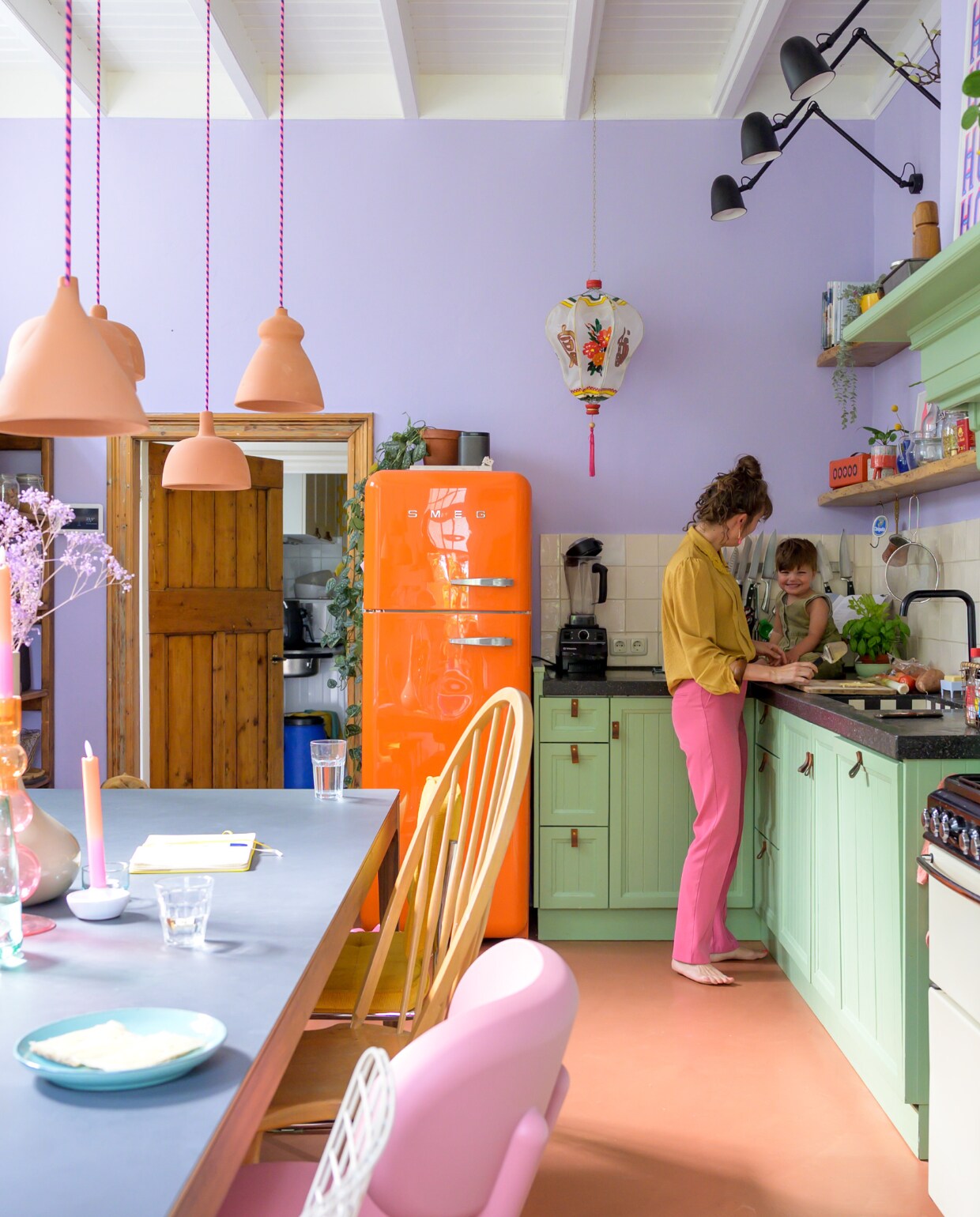 Leonie en Moos in de keuken van hun Overijsselse boerderij. Fornuis Stoves van Richmond, kraan Talis M 54 220 van Hansgrohe, tegels Azulejos Blanco Cristal van Designtegels, koelkast Smeg, keukenmachine Vitamix. Wandlampen Ikea, Chinese hanglamp Kitsch Kitchen. Keuken op maat gemaakt door vorige bewoner, wandplank maatwerk door lokale timmerman. Overig onbekend. vtwonen special binnenkijken 121-2023 | fotografie Trui Heinhuis