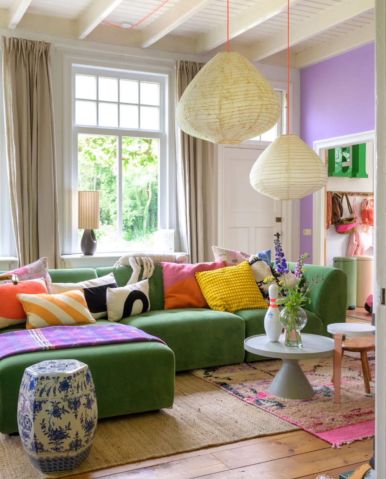 Muurverf WO.20.60 van Flexa. Bank en hanglampen HKliving, kussens Ikea, Fatboy, Urban Nature Culture, Van Verre en kringloopwinkel, plaid Van Verre. Bijzettafels Loods 5 en Gert Snel, kegel Vintage Friends, vaas Urban Nature Culture, krukjes TipToe. Gordijnen Karwei. Vloerkleden Evenaar en WanderWood. Overig onbekend. vtwonen special binnenkijken 121-2023 | fotografie trui heinhuis