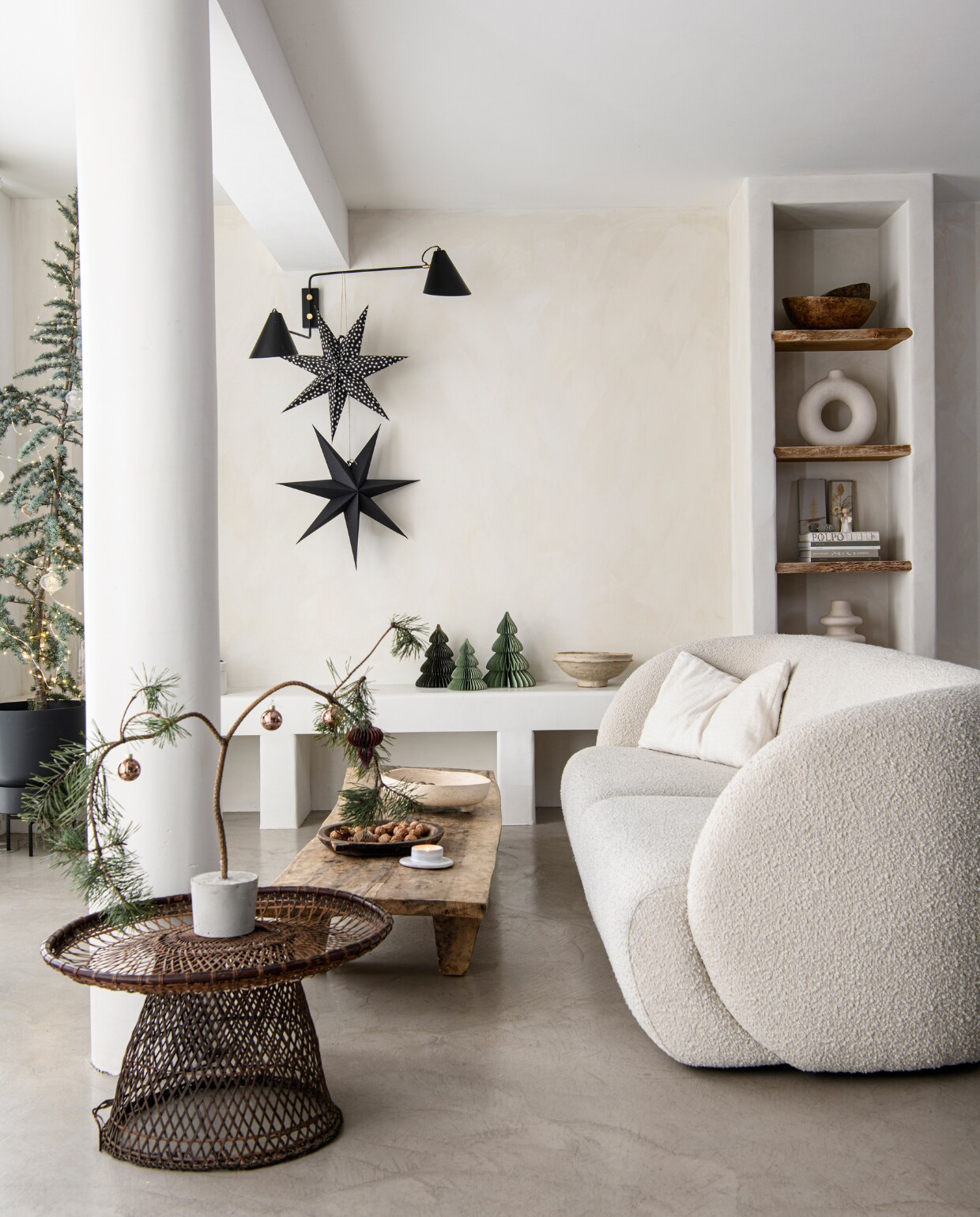Vloer Tav Microcement, muurverf Fresco in Bone van Pure &amp; Original. Driezitsbank Paul van Sofacompany. Salontafel Nagaland en schalen in kast Vanheesdesign. Gevlochten bijzettafel, zwarte schaal en zwart kaarsplateau Raw Materials. Zandkleurige schaal en zwart-witte kerststerren Loods 5. Poef Household Hardware, blauwe ceder Intratuin. Ornamenten, vazen en tafelkleed H&amp;M Home. Plantenpot Tuincentrum Osdorp, cadeaudozen verzameld. Uitvouwkerstbomen Hema en MrsBloom. Wandlamp en zwarte kerstster House Doctor. Doos met ingelegde droogbloem Loesje van Herp, tafel HKliving, hanglamp Ball Filigrain XXL van Zenza Home, kaars Casa. vtwonen 13-2023 | productie Insidehomepage | fotografie Louis Lemaire