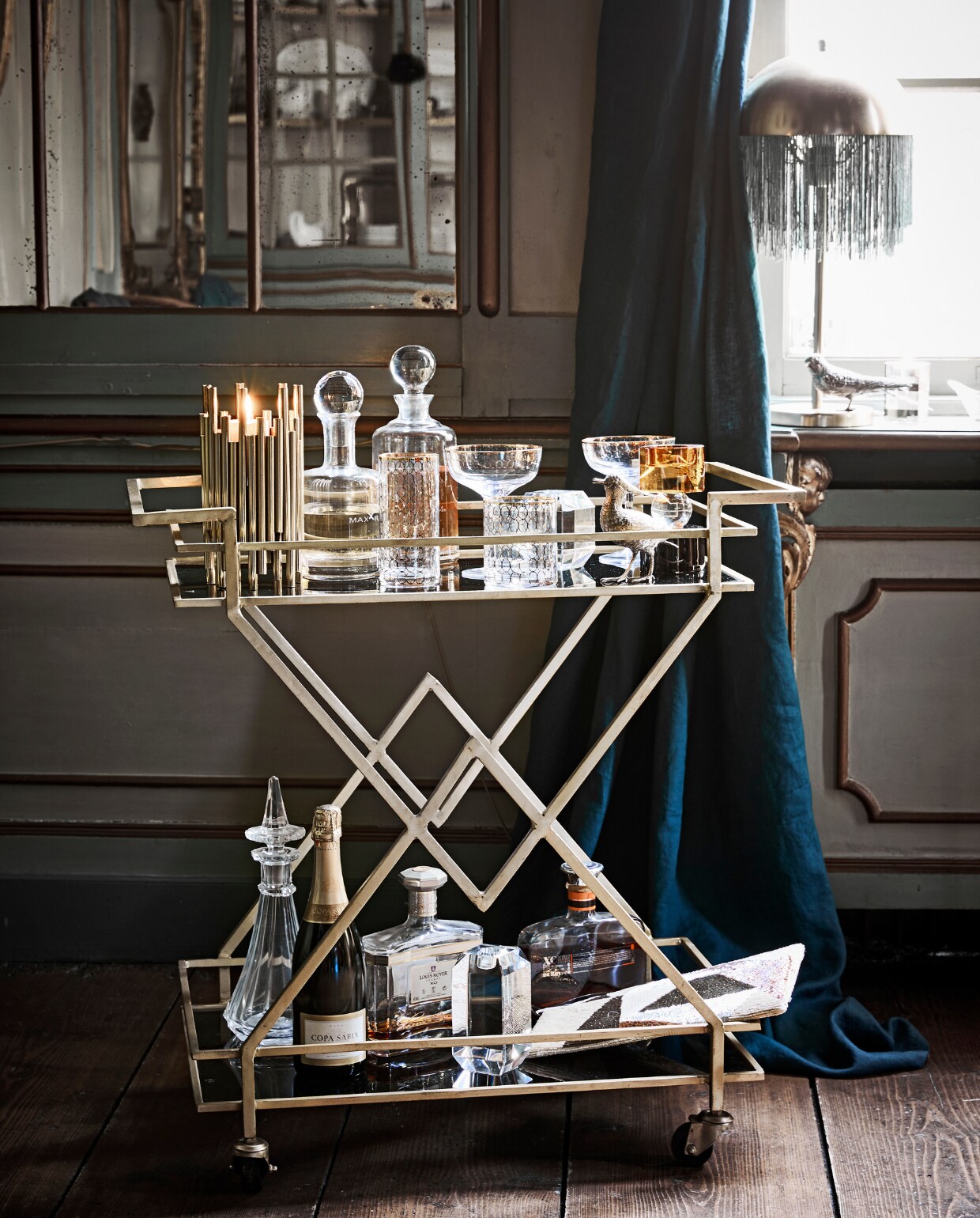Trolley, cocktailglazen met goud, tafellamp met franjes hoogte 50 cm, avondtasje met kraaltjes, longdrinkglas met goud, laag glas met goud goudkleurige buisjeskandelaar, glazen kandelaar met oker en zwart, helder facet geslepen glazen karaffen (Nordal). Antieke karaffen en oude drankflessen, verzilverde vogels soortgelijk (Prinsheerlijk Antiek). Overig privébezit. vtwonen 12-2018 | styling Cleo Scheulderman | fotografie Jeroen van der Spek | assistentie Mette van der Hoek