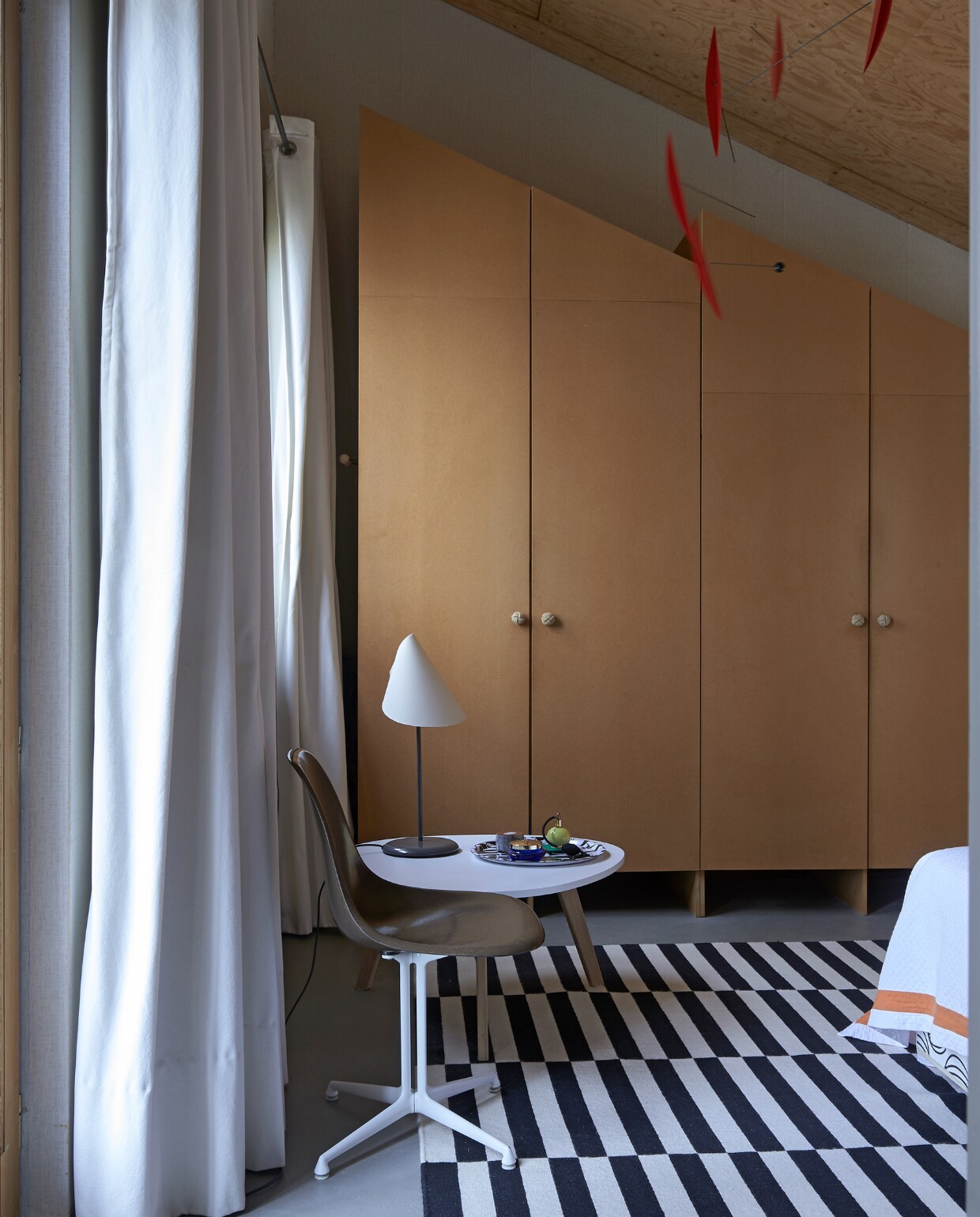 Fiberglass kuipstoel van Eames voor Vitra naast tafeltje uit budgetwinkel. Tafellamp La Lune sous le Chapeau van Man Ray voor Sirrah. Kleed Stockholm Ikea. De kast van mdf ontwierp Aart zelf. Aan het plafond een mobile à la Alexander Calder. vtwonen special binnenkijken 03-2020 | styling Rob Jansen | fotografie Dennis Brandsma