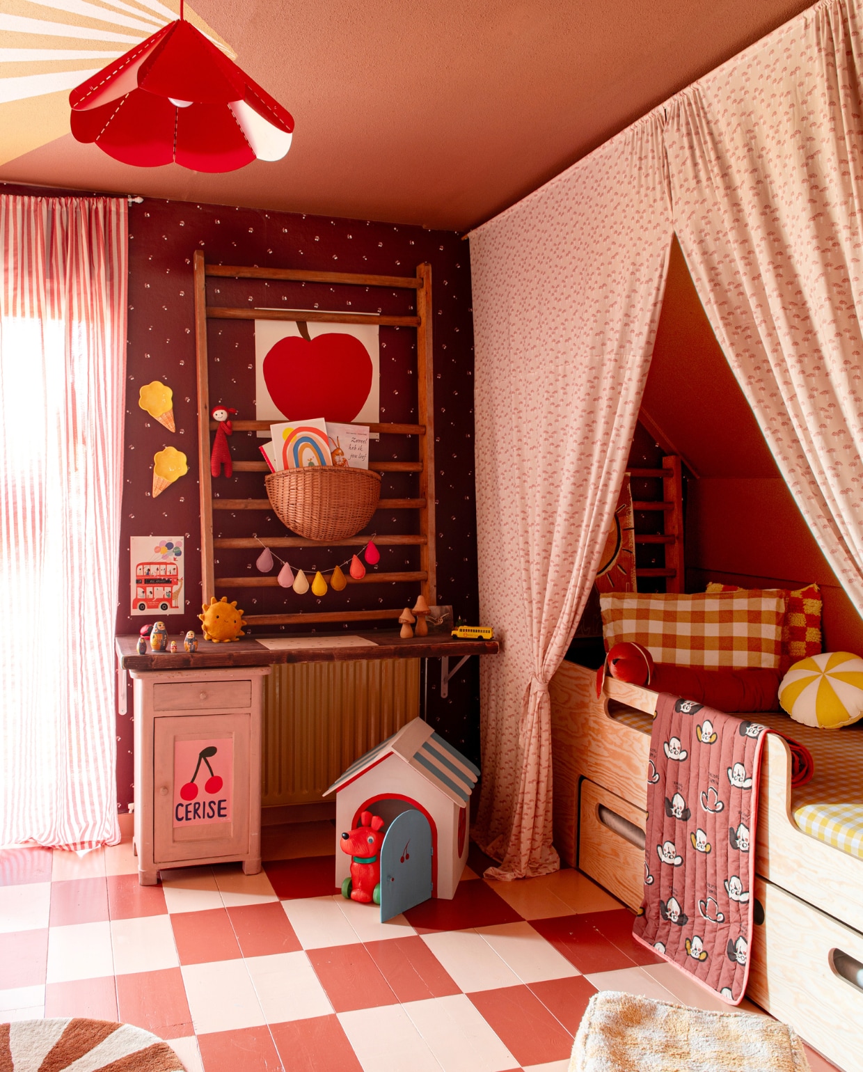 Muurverf plafond Middle Buff van Little Greene. Gordijnen en hondenhok zelfgemaakt. Behang Rebloomed, bedgordijnen Family Fabrics. Klimrek en kast vintage. Poster Wolfnoodle. Mand en vloerkleed Ferm Living. Hanglamp Ikea, bed Petit Puk, rond kussen Moi Mili, plaid StudioLoco, poef Lorena Canals. Overig onbekend. vtwonen 01-2024 | styling Linda van der Ham | fotografie Caroline Coehorst