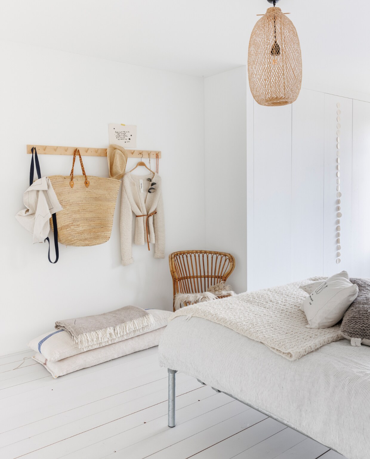 Kapstok Iris Hantverk, vest Atelier Sukha, rieten mand en kussens BijDaan. Bed zelfgemaakt van steigerbuizen. Lamp Bloomingville van BijDaan. Overig onbekend. vtwonen special binnenkijken 12-2023 | fotografie Margriet Hoekstra