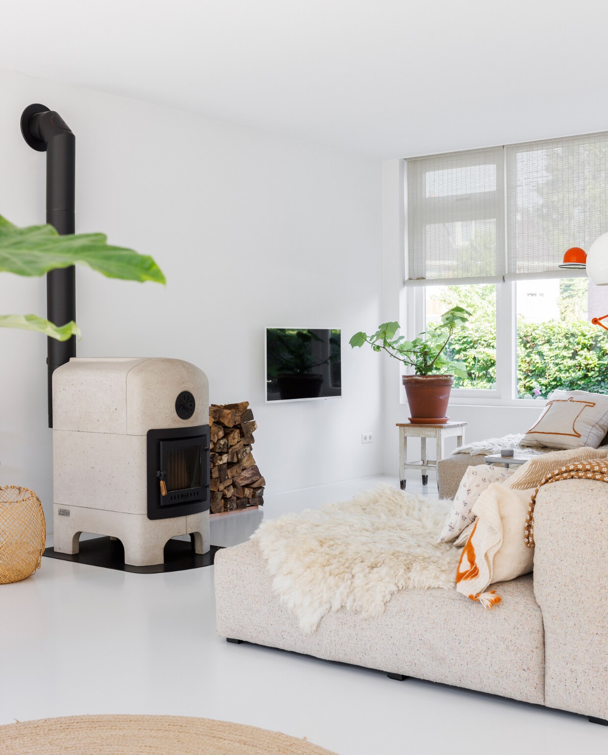 Verfkleur vloer Shallows van Little Greene. Kachel De Klein &amp; Van Hoff. Bank Mags Soft van Hay met stof van Kvadrat, schapenvacht en kussens BijDaan. Houten rolgordijnen Baltex Blinds. Overig onbekend. vtwonen special binnenkijken 12-2023 | fotografie Margriet Hoekstra