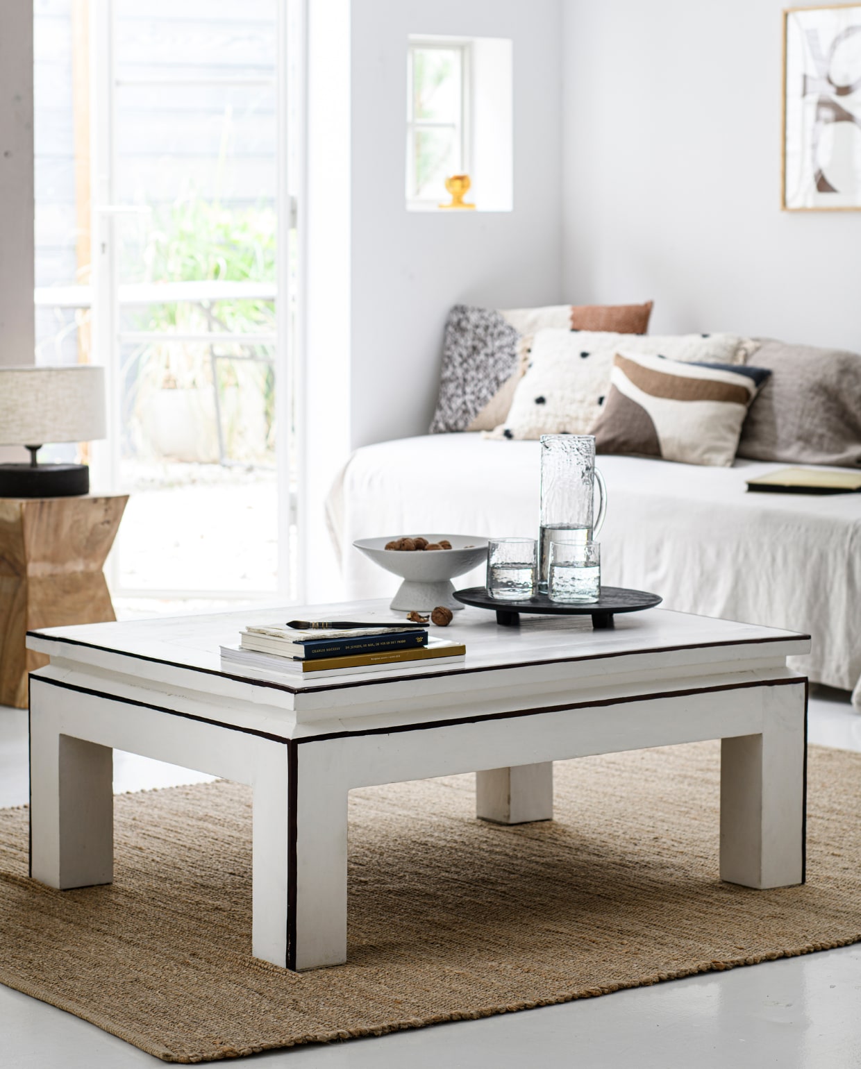 Witte schaal op voet, zwart dienblad, kandelaar in raam en glaswerk (tablejoy.nl). Lamp (zarahome.com). Gestipt kussen (weldaad.com). Vloerkleed en overige kussens (wehkamp.nl). vtwonen special DIY 08 | productie Inside Homepage | styling Anja Bas Backer, Laura Gommans | fotografie Louis Lemaire