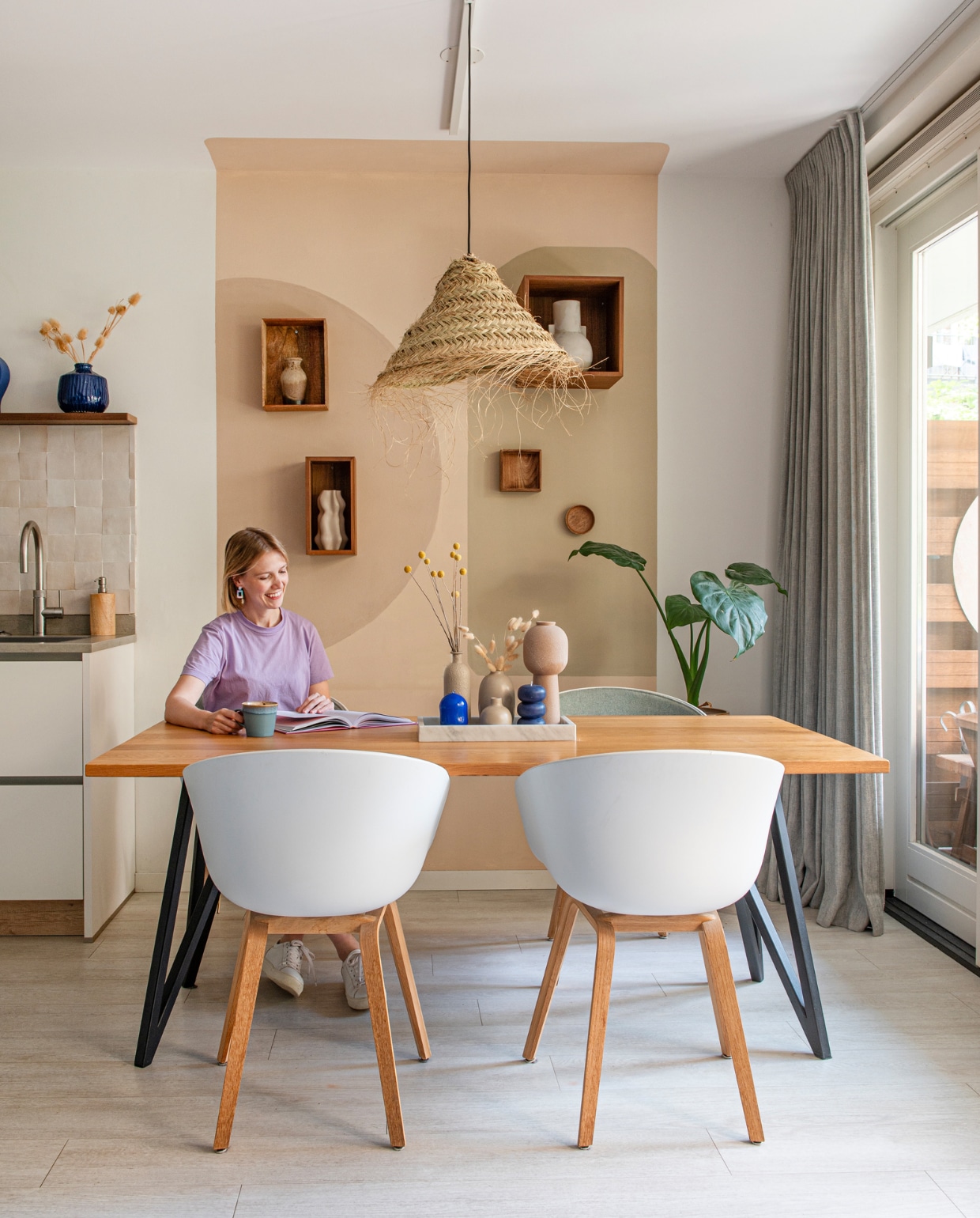 Tafel Studio Henk, gestoffeerde kuipstoelen Hay, hanglamp By Bamboo Beach Living. Wandkasten Bolia en H&amp;M Home. Keuken Hcker, tegels The Mosaic Factory, blauwe vaas Intratuin. Muurkleuren zelf gemengd. Overig onbekend. vtwonen 01-2024 | fotografie Caroline Coehorst