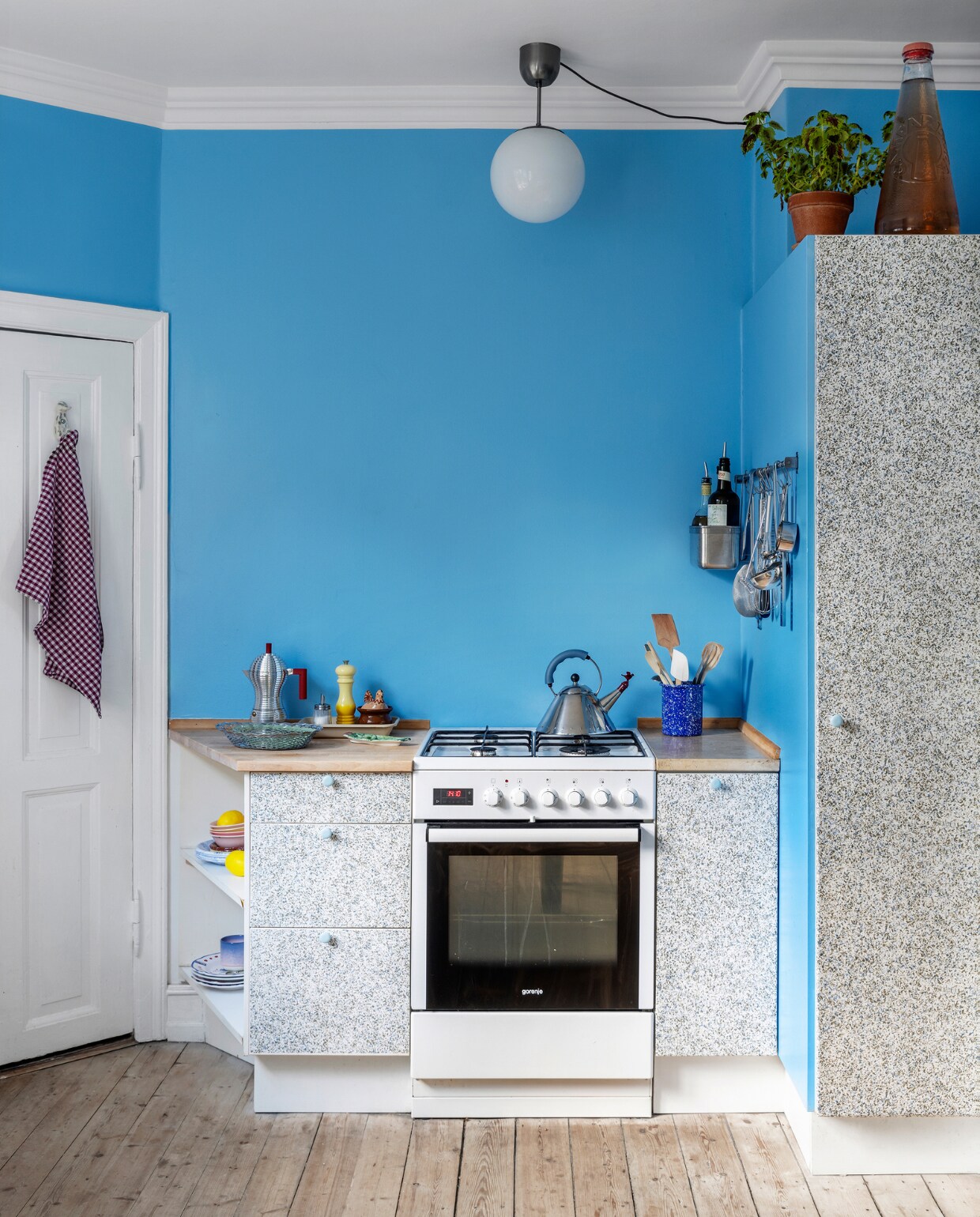 Keuken gewrapt met meubelfolie en hanglamp Ikea. Espressomaker Pulcina van Alessi, broodmanden Kiosk48th, porseleinen schaal artisjok souvenir uit Toscane, pepermolen Soleil van Le Creuset. Overig onbekend. vtwonen special binnenkijken 121-2023 | productie Living Inside | styling Rikke Graff Juel | fotografie Christina Kayser Onsgaard