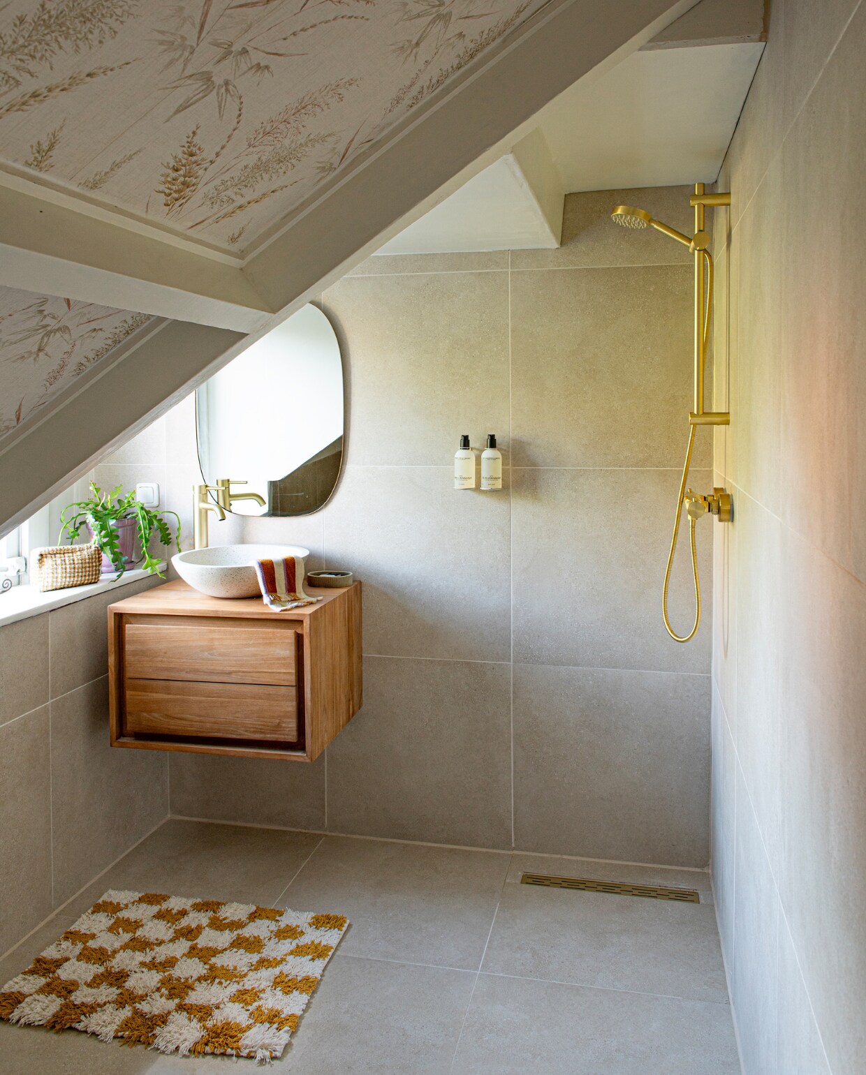 Wastafelmeubel en waskom Kave Home. Douche en kraan Saniclear. Zeeppompjes Meraki zelf beige gespoten, spiegel Zara Home, vloer- en wandtegels Betonico van Rako. Douchemat en gastendoekje Sissy-Boy. Behang HKliving. Overig onbekend. vtwonen 01-2024 | productie De Binnenkijkers | styling Jeske Weel | fotografie Caroline Coehorst