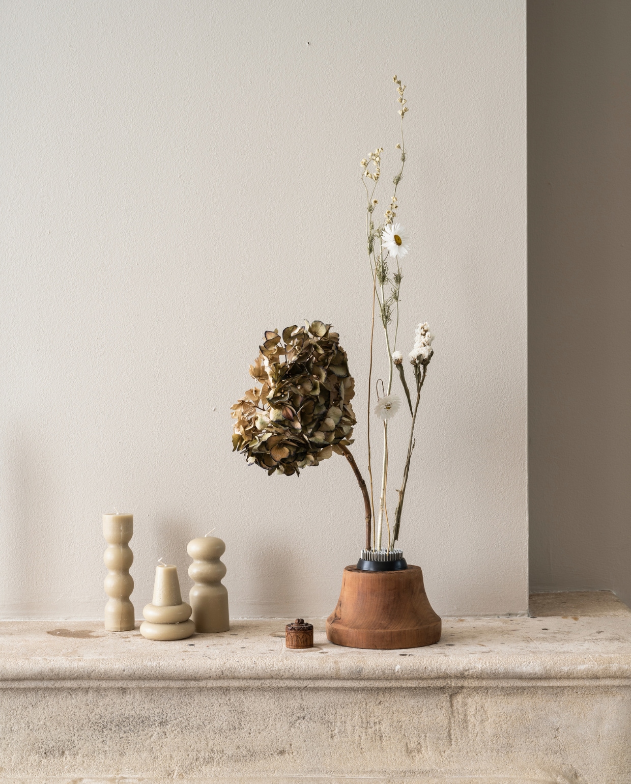 Waxkaarsen Torno van Ferm Living, set van 3 € 39,- (vtwonen.nl/shop). Bloemprikker Kenzan € 15,-(bol.com). Droogbloemen € 24,95 (bloomon.nl). Hortensia zelf gedroogd vtwonen 2024-01 | productie corrien flohil, rolien van der leeuw | styling kelly van gendt | fotografie stan koolen