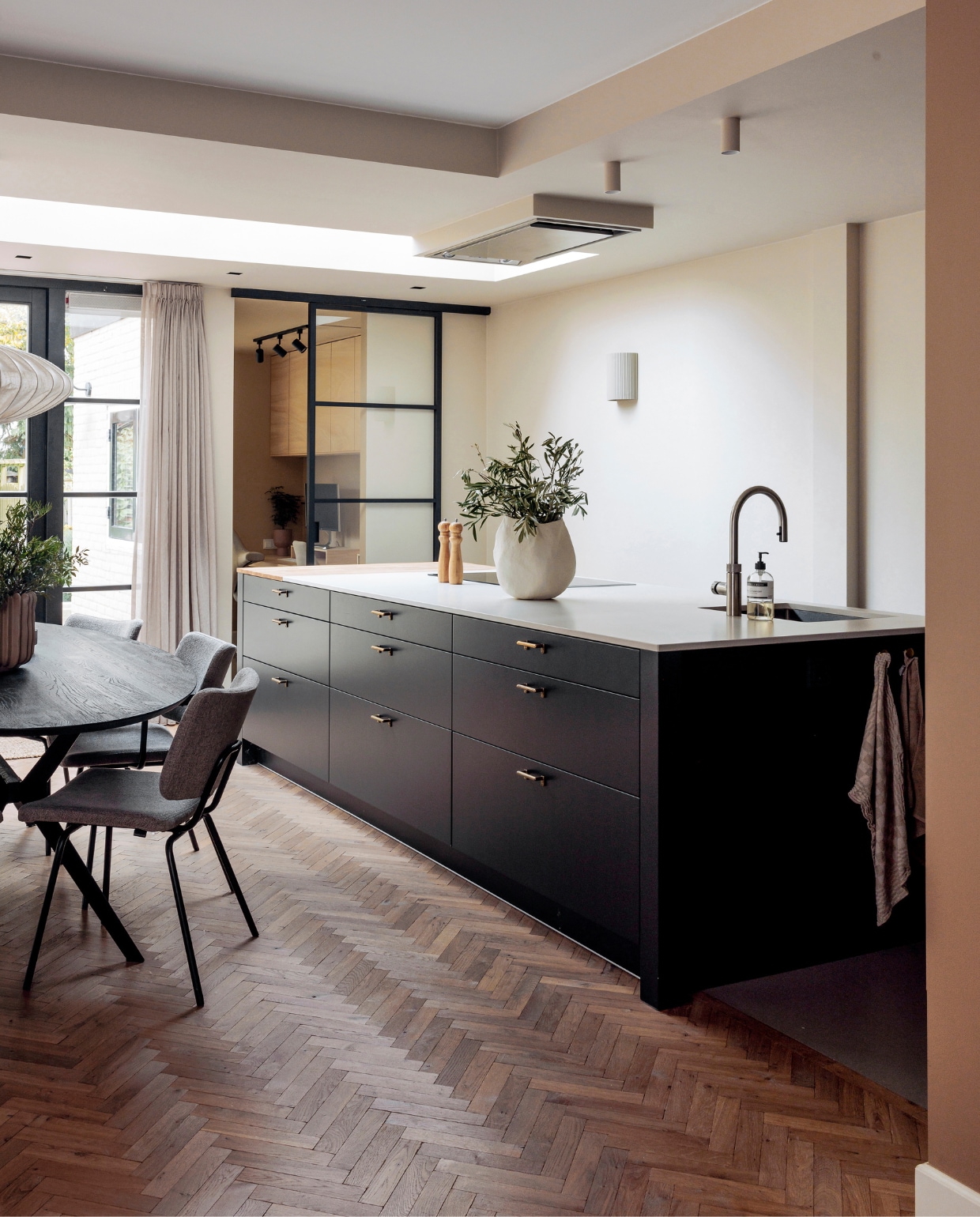Keuken Keur Keukens, schuifdeur GewoonGers, vloer Loven Tapis van De Woonzaken, eettafel Ramses van Bodilson, eetkamerstoelen Patch van Bodilson, wandlamp Hilko van Westwing Collection. Muurkleur Crushed Silk van Histor, gordijnen Jorrit van Kwantum. Peper-en-zoutstel Loods 5, vaas zelfgemaakt. Kasten kantoor Ivar van Ikea. Overig onbekend. vtwonen 01-2024 | fotografie Ernie Enkelaar