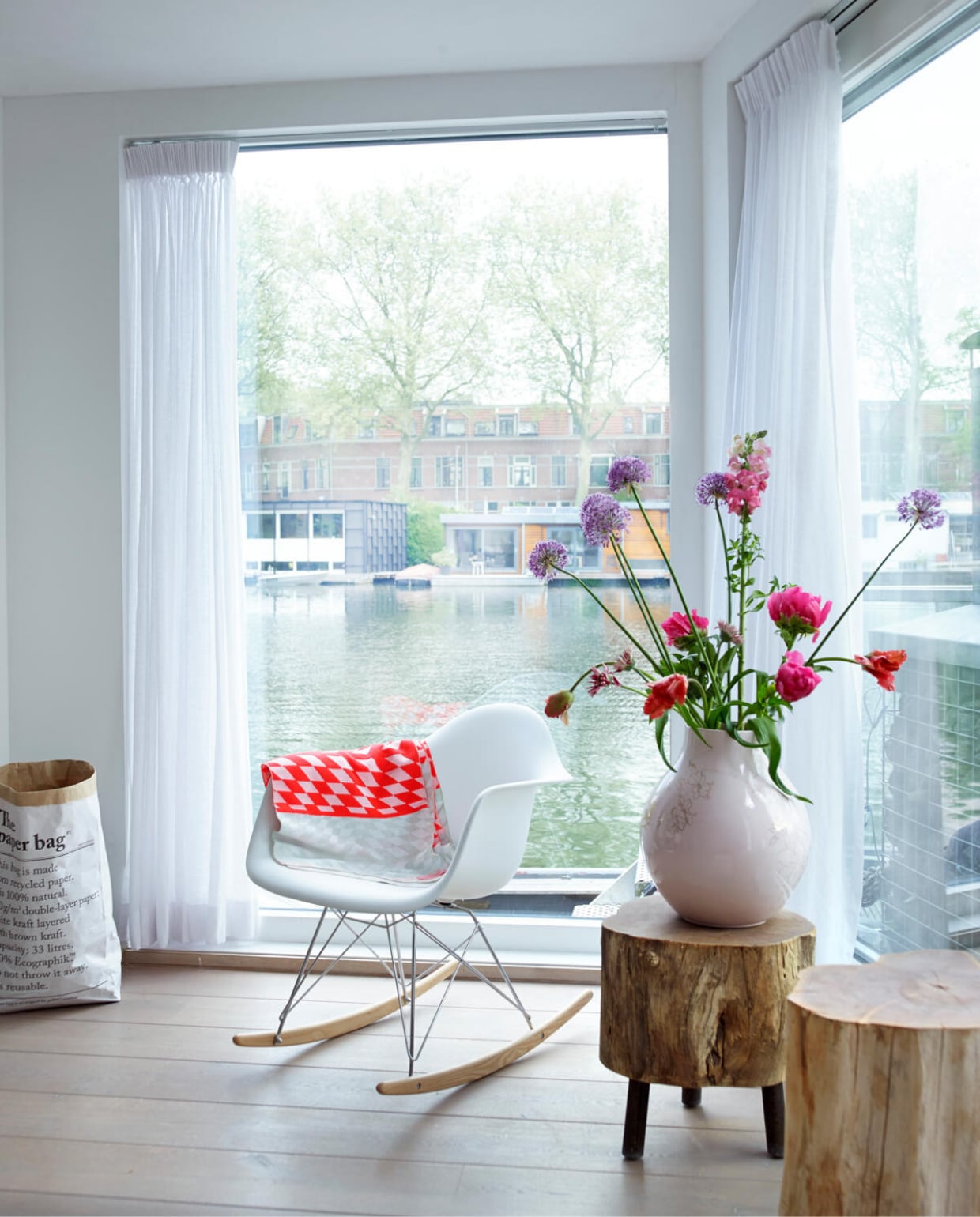 Recent gekocht: de Eames look-a-like van Domini Design, om over het water uit te kijken. Het dekentje is eigenlijk een shawl van Mae Engelgeer. (VT FLAVOURITE)Elke avond wordt het speelgoed van de kinderen opgeruimd – de bedoeling is dat Finn en Kiki het zelf doen - en in My Paper Bag (via Flavouritesstore) opgeborgen. De boomstamkrukjes met de Hella Jongerius-vaas van Ikea heeft Natascha al een aantal jaar. vtwonen 07-2014 | Fotografie Tjitske van Leeuwen | Styling Marianne Luning