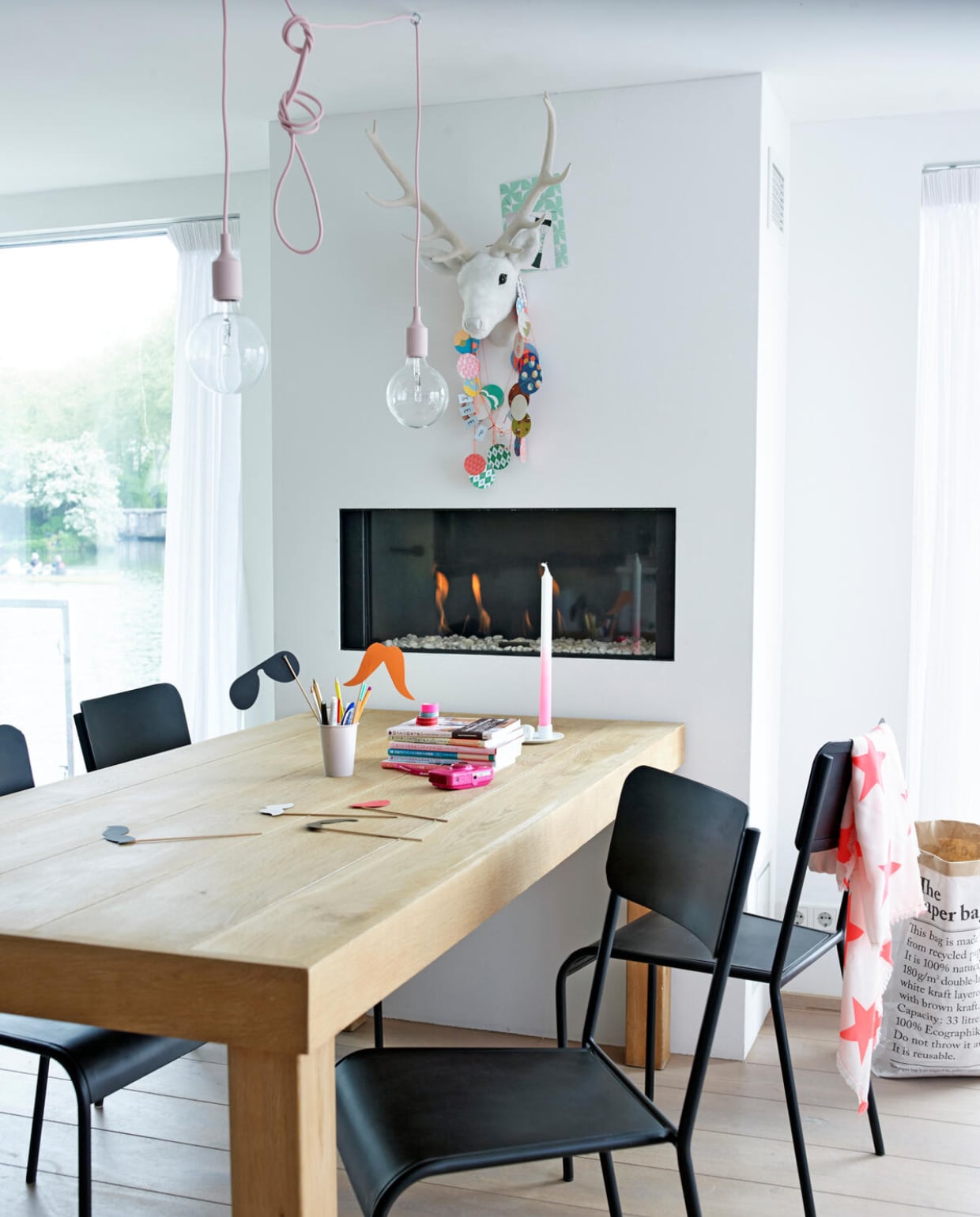 De houten eettafel is gemaakt van overgebleven vloerdelen. Vervolgens zijn ze met ultramatte tweecomponentenlak (van Trae Lyx) behandeld. Zo kun je nog eens fijn knoeien zonder dat het zichtbaar is. Zwarte stoelen van Gigameubelindustrieel via Flavouritesstore.nl. Lampen: Muuto via flinders.nl. ‘De gasleidingen van de haard zijn meteen bij de bouw aangelegd. Vier jaar later volgde – bij een groter budget - de open haard.’ vtwonen 07-2014 | Fotografie Tjitske van Leeuwen | Styling Marianne Luning