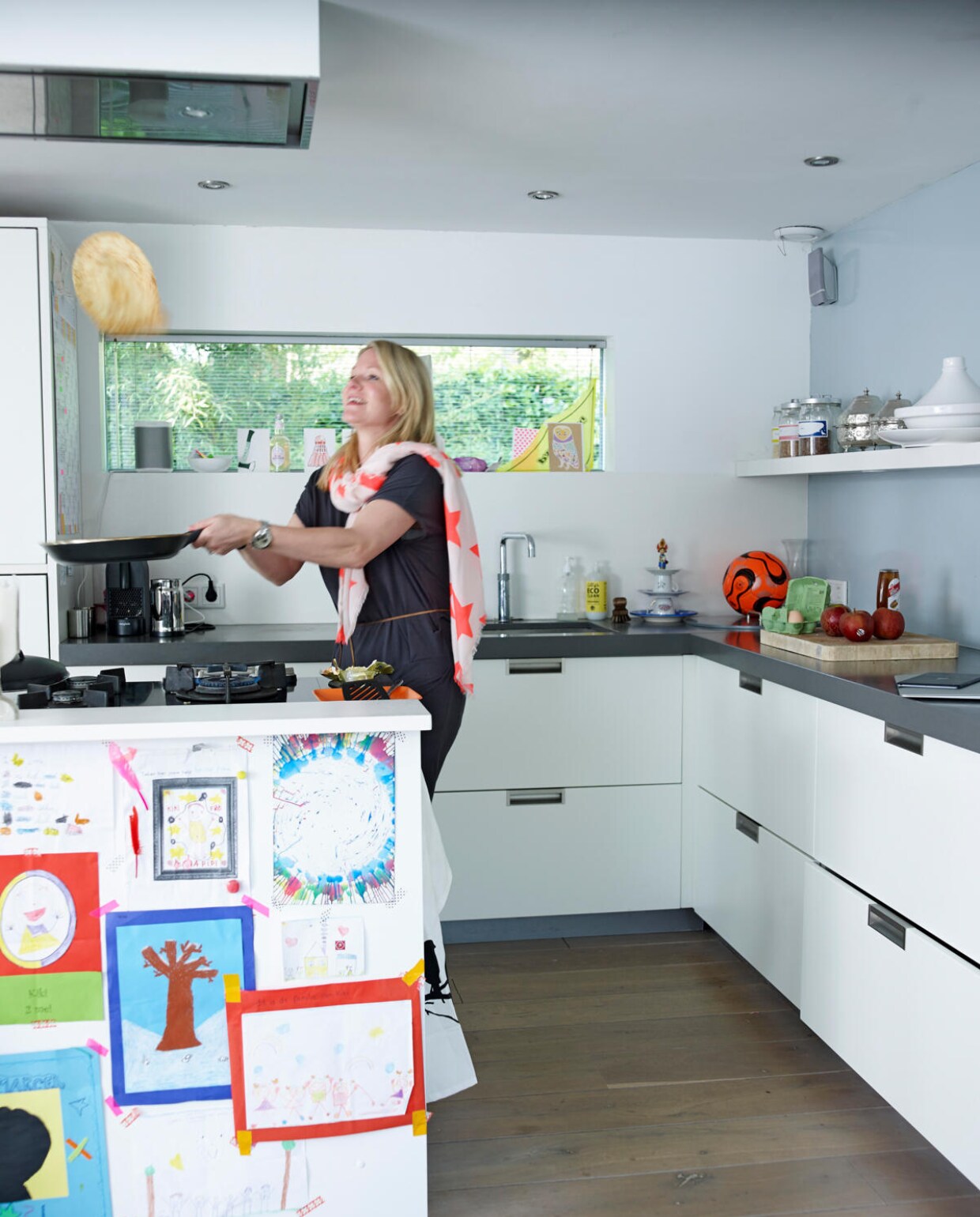 De keuken is (op maat) gemaakt aan de tuinkant. Achter het kookeiland is er vol uitzicht op het water. Eigenlijk heeft Natascha het liefst een lege vensterbank, maar op wonderbaarlijke wijze verzamelen zich daar allerlei spulletjes. vtwonen 07-2014 | Fotografie Tjitske van Leeuwen | Styling Marianne Luning