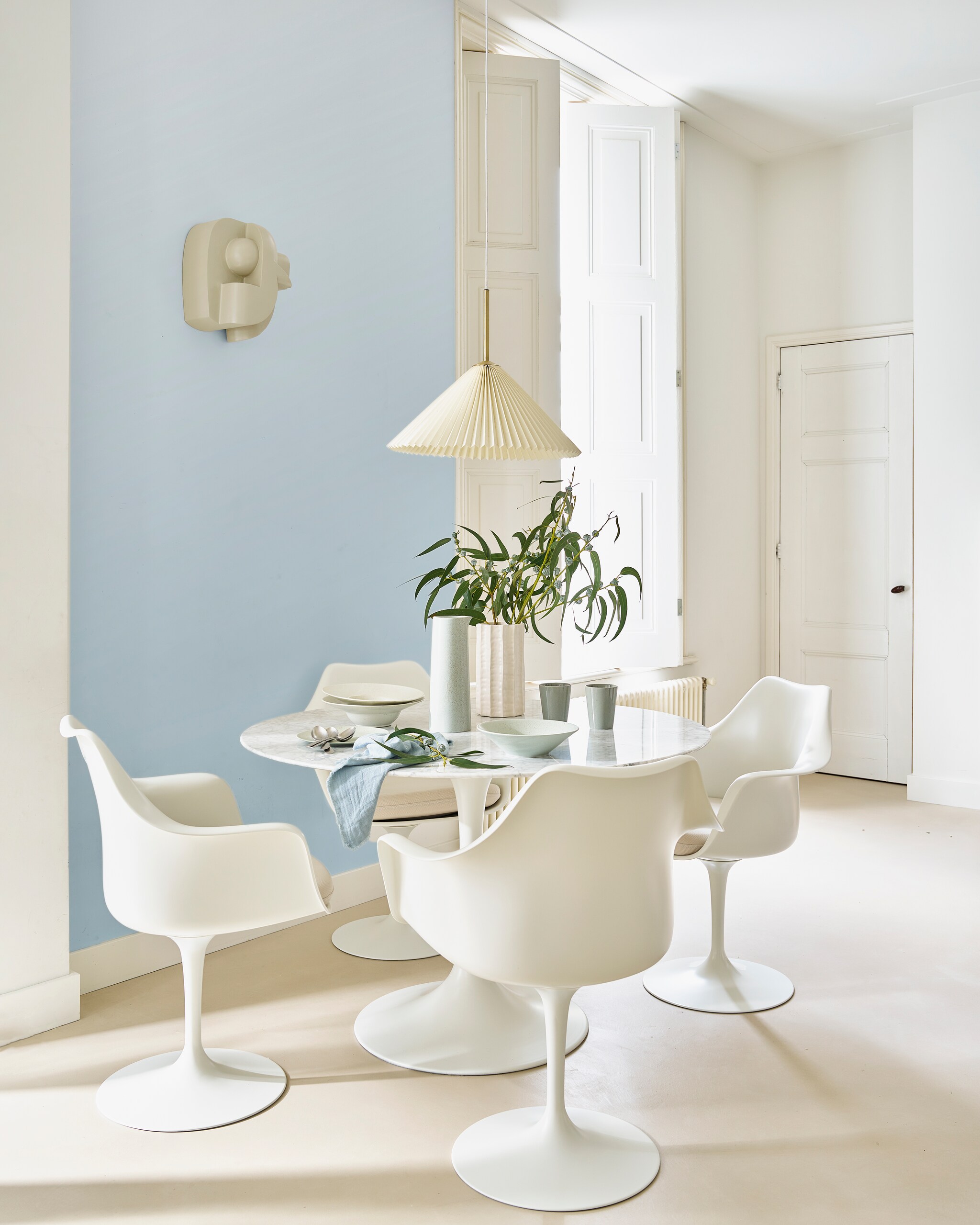 Marmeren tafel Tulp, 120x75 cm (Øxh) € 1249,-, stoelen Tulp met armen, glasvezel en metaal, per stuk € 499,- (marmerentulp.com). Keramieken pastabord Grawa € 42,42 (nordal.com). Porseleinen kan Ogawa Sea Foam € 49,95, porseleinen bekers € 10,95, bord vanaf € 8,95, schaal € 24,95, keramieken vaas Vieira € 39,95 (urbannatureculture.com). Wandsculptuur van Edith Beurskens en Ilse van Stoltz, prijs op aanvraag (edithbeurskens.com, ilsevanstoltz.com). Servet € 5,95 (iblaursen.nl). Muurverf All White 2005 van Farrow &amp; Ball, 2,5 liter € 102,- (paint-paper.nl). Overig privébezit. vtwonen 03-2024 | styling Cleo Scheulderman | fotografie Jeroen van der Spek