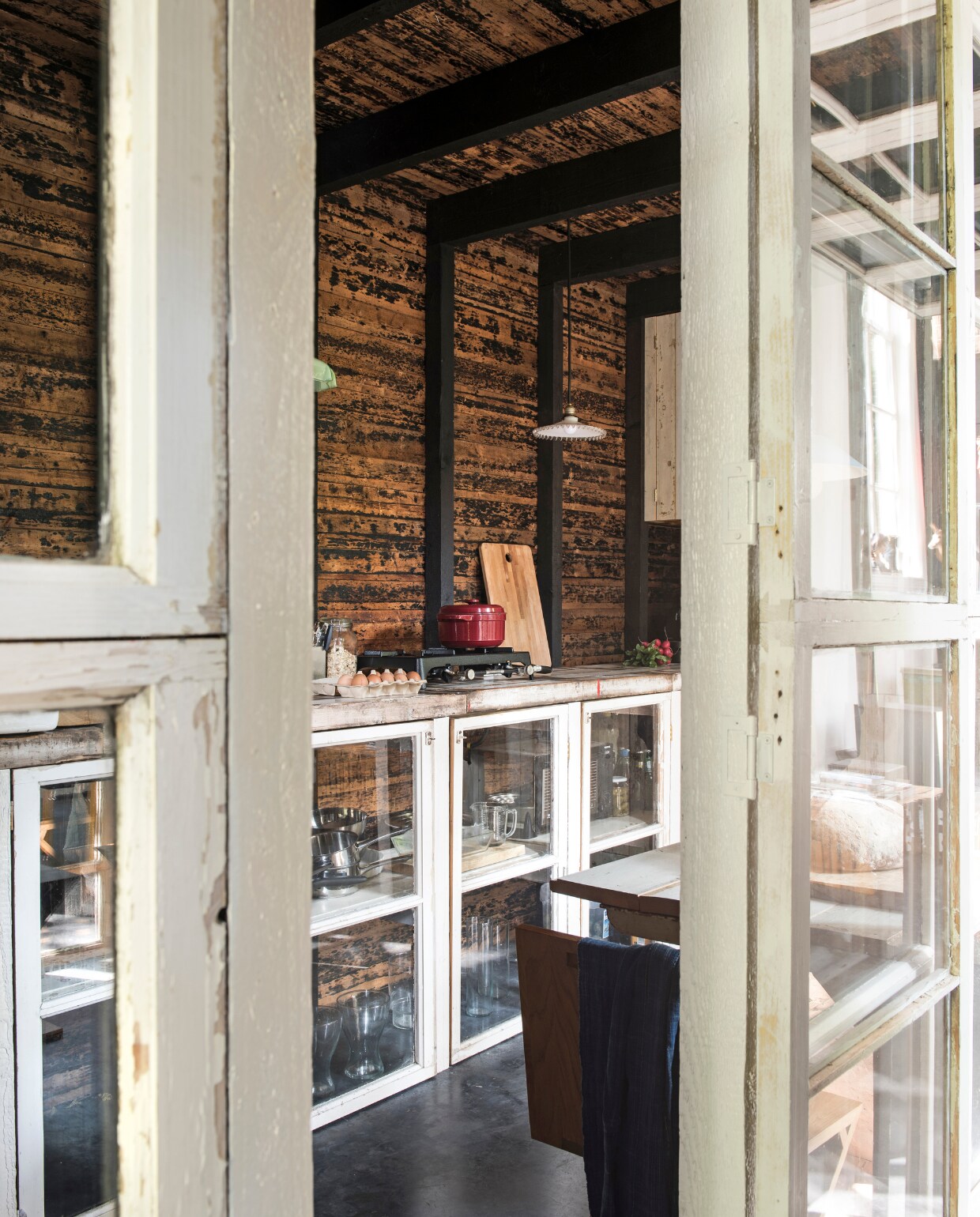 De houten deuren geven toegang tot de afgesloten keuken. vtwonen 03-2017 | Styling Inge van Lieshout | Fotografie Louis Lemaire/Insidehomepage