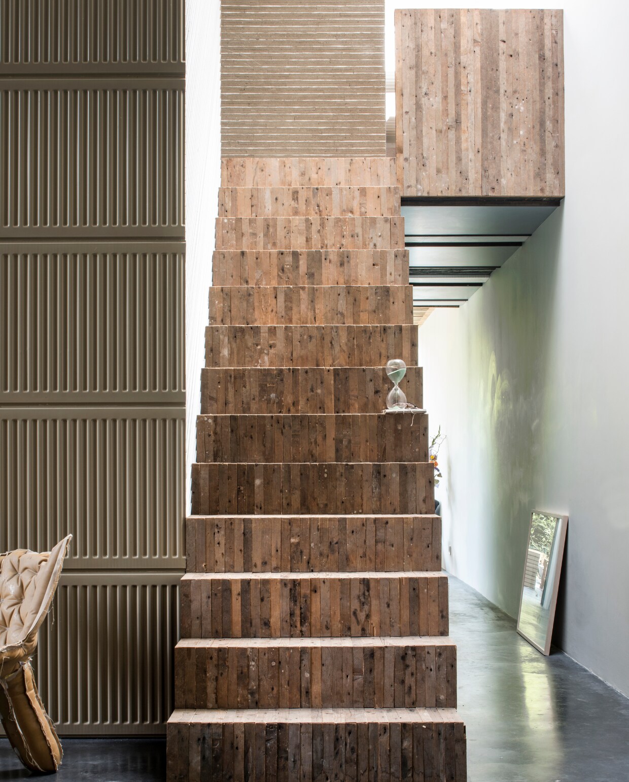 Trap bekleed met vloerhout. In de gang rechts zit een toilet en is in kasten plek voor de wasmachine en de cv-installatie. vtwonen 03-2017 | Styling Inge van Lieshout | Fotografie Louis Lemaire/Insidehomepage