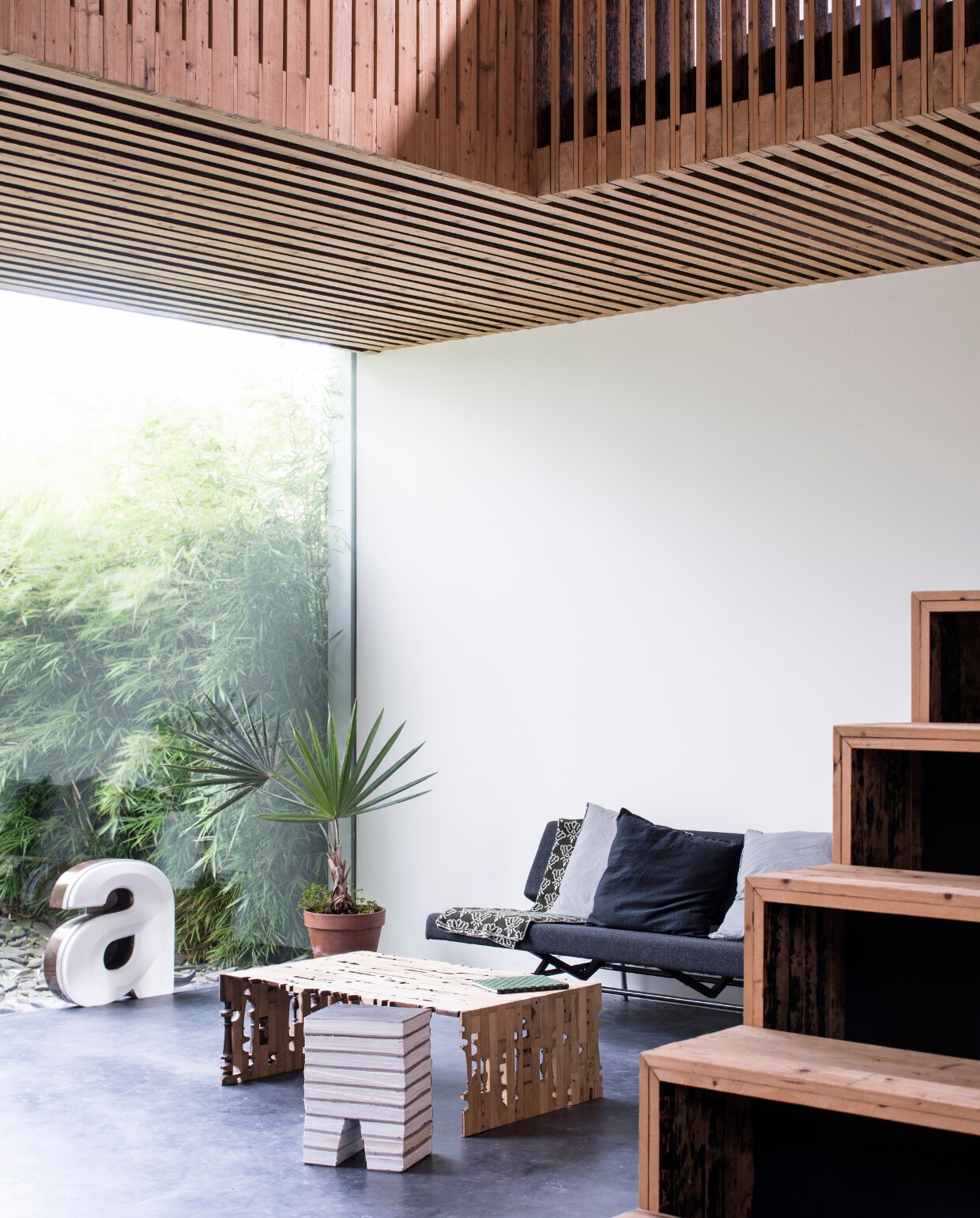 Zwarte bank van Mart Visser voor Spectrum. Houten salontafel Slices of Henry Deux, bijzettafel Princely Stool, allebei ontworpen door Rolf. Vintage letter gekocht van Mannin. vtwonen 03-2017 | Styling Inge van Lieshout | Fotografie Louis Lemaire/Insidehomepage