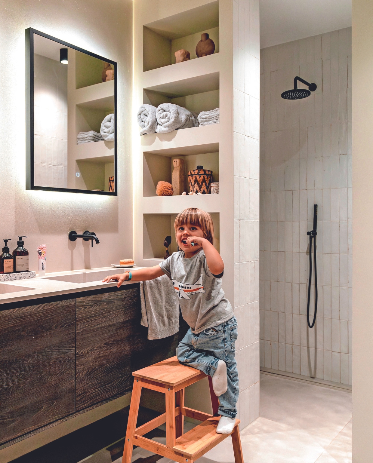 Muurkleur Shaded White van Lab Paint. Vloertegel Powder Smoke en wandtegel Lume White van Marazzi. Badkamermeubel, kranen en douche Tortu World. Spots Rietveld Licht, spiegel Sanidirect, zeeppomp Meraki, schaal Dille &amp; Kamille. In kast: mand Casa Gitane, vaas 101 Copenhagen, handdoeken de Bijenkorf, spons Natuurspons, sculptuur uit Bali, trap Ikea. Overig onbekend. vtwonen 02-2024 | fotografie Myrthe Slootjes | tekst Mirjam Rosema-Verhulst