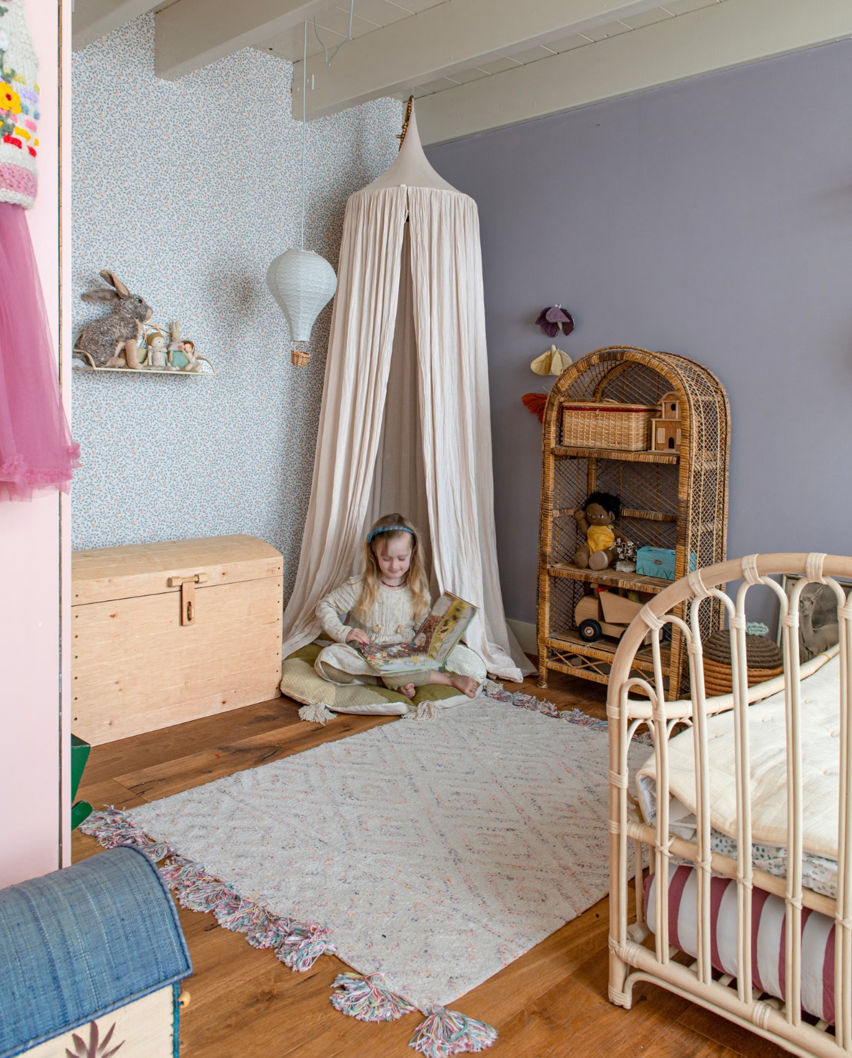 Muurverf Silver Mauve van Flexa. Behang Climbing Rose van Summer Gray. Kist Loods 5, luchtballon Cam Cam Copenhagen, bedhemel Numero 74, rotan rek op straat gevonden, bed Leo &amp; Moon, vloerkleed Kwantum. Overig onbekend. vtwonen special binnenkijken 121-2023 | productie De Binnenkijkers | styling Jeske Weel | fotografie Caroline Coehorst