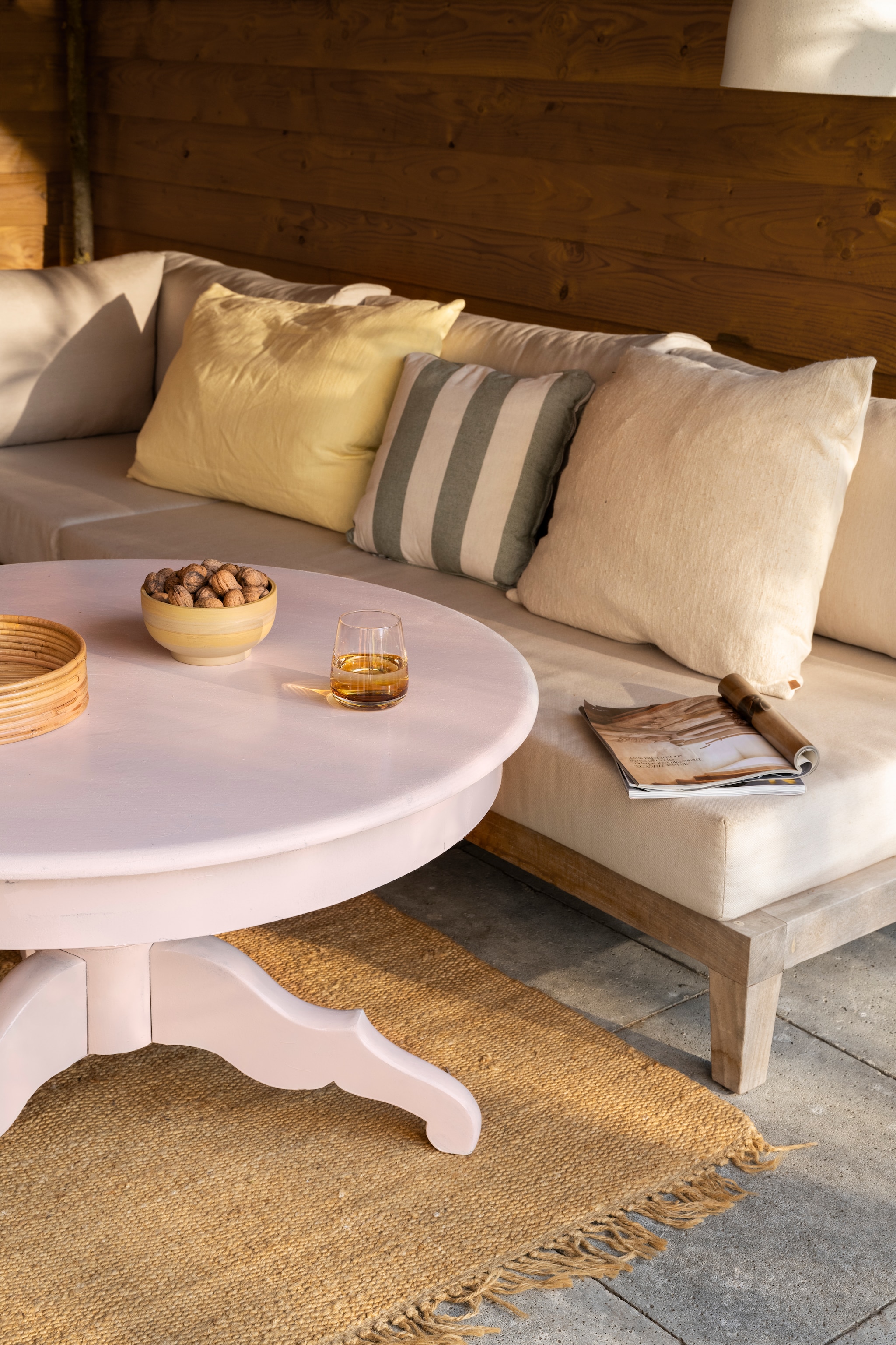 Salontafel van de kringloop gelakt in buitenlak Pink Peach van Lab Paint, glansgraad gloss, 500 ml € 53,- (vestingh.nl). Rotan dienbladen Isola van Ferm Living. Lichtgeel linnen kussen Heavy Linen van Ferm Living in Lemon, 50x50 cm € 69,-, beige katoenen kussen Nettle van Ferm Living, 60x80 cm € 139,- gestreept kussen Bold Square van vtwonen, gerecyclede materialenmix, 45x45 cm € 44,95 (vtwonen.nl/shop). Overig privébezit. vtwonen 07-2024 Kringloop | styling Kelly van Gendt | fotografie Stan Koolen