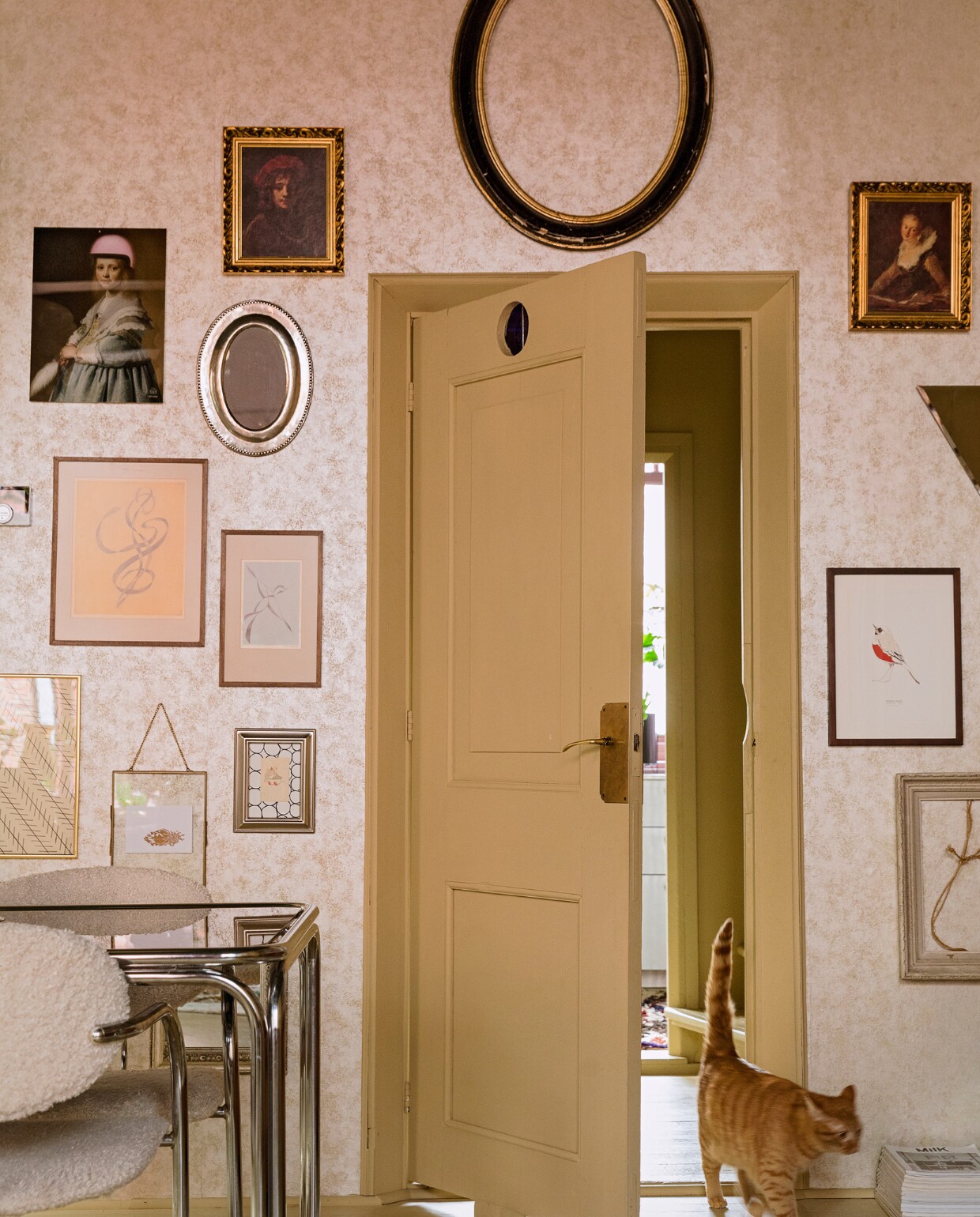 Behang Fenton in goud van 1838 Wallcoverings. Verfkleur houtwerk Bisquit van Painting The Past. Vintage tafel en stoelenLiving Once, zelf gestoffeerd. Vloerkleed The Souks. Verzameling lijsten erfstukken, cadeau gekregen en kringloopwinkel.Print Meisje in het blauw met roze helm Arti-shock, print roodborstje Maartje van den Noort, overige herkomst onbekend. vtwonen 06-2021 | styling Ilona Jongepier | fotografie Dana van Leeuwen