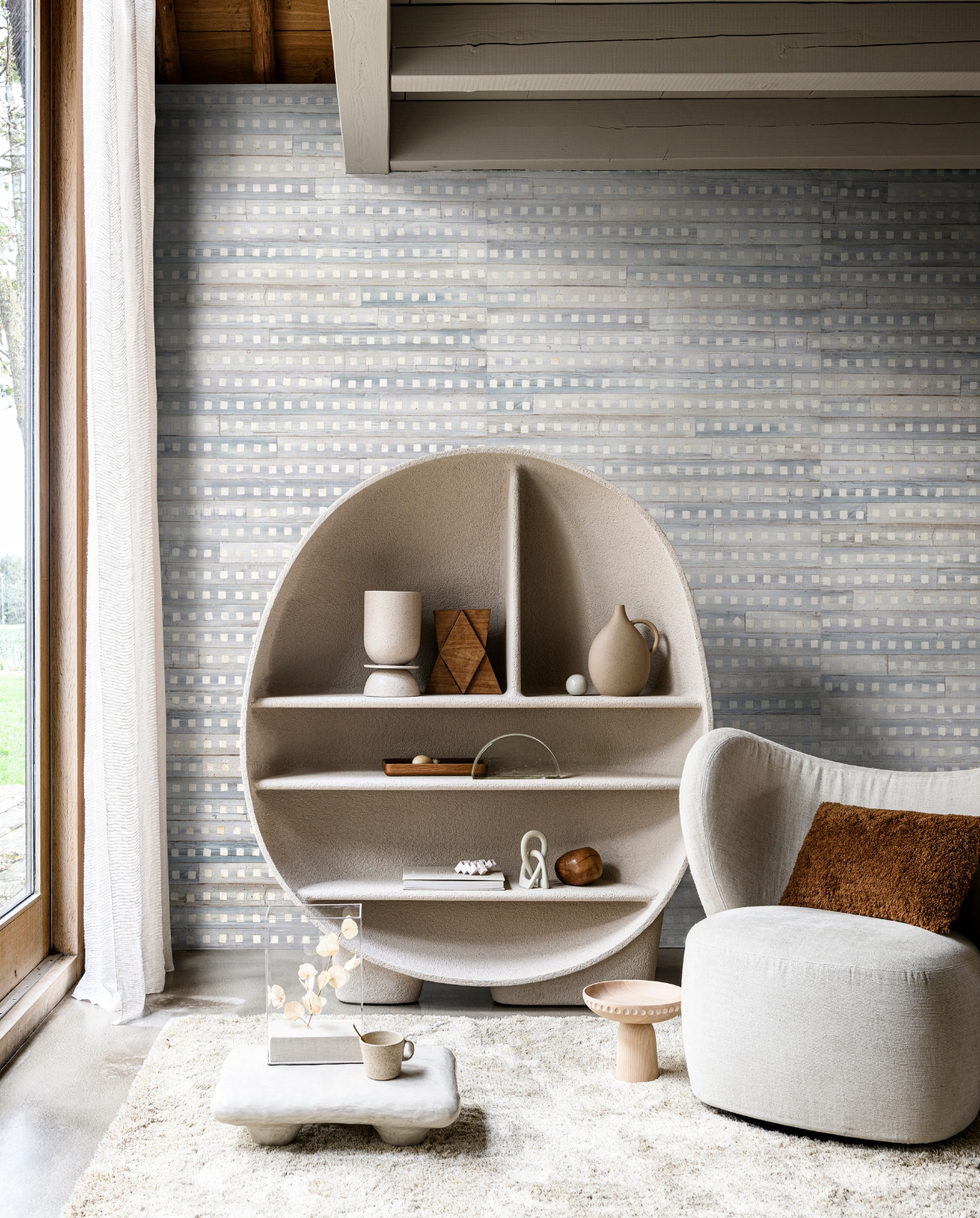 Behang Iloilo uit collectie Ecrin van Elitis, 110 cm breed, per meter € 265,- (loggerewilpower.com). Gordijn Sidon Voile van Nobilis, 290 cm hoog, per meter € 143,- (wva.nl). Kast, 131x156x42 cm (bxhxd) € 4510,- (roche-bobois.com). Vloerkleed Aventura, prijs op aanvraag, lichte houten etagère € 163,- (kasstoor.nl). Lage bijzettafel € 520,-, houten beeld € 125,-, wit kubusobject € 100,-, beige knoopobject € 30,-, houten steen € 48,- (studio-yen.com). Kunststof stolp met linnen voet € 89,95, glazen ornament halve maan € 124,95 (hkliving.nl). Keramieken mok € 44,90 (letoile.store). Fauteuil Little Big Chair, 77x75x76,5 cm (bxdxh) € 1999,- (nor11.com). Kussen € 40,- (paviljoennoord.com). Vaas met drie elementen € 73,-, houten dienblad € 75,- (bolia.com). Stenen vaas met handvat € 35,99 (zarahome.com). Overig privébezit. vtwonen 13-2020 | styling Daniëlle Verheul | fotografie Sjoerd Eickmans
