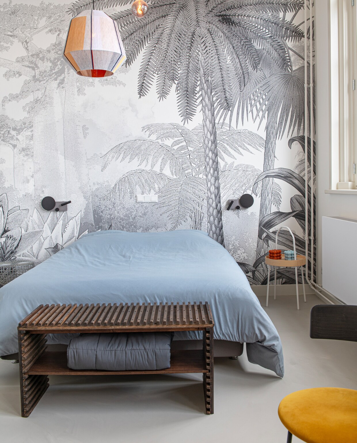 Behang Artwallcollection, stoel Fest Amsterdam, grote hanglamp Hay, kleine hanglamp Ikea, wandlampen Klee van Faro. Houten bank door Linda Post van TTOTT Design, bijzettafel, bed en beddengoed Ikea. Overig onbekend. vtwonen special binnenkijken 11-2023 | productie De Binnenkijkers | styling Jeske Weel | fotografie Caroline Coehorst