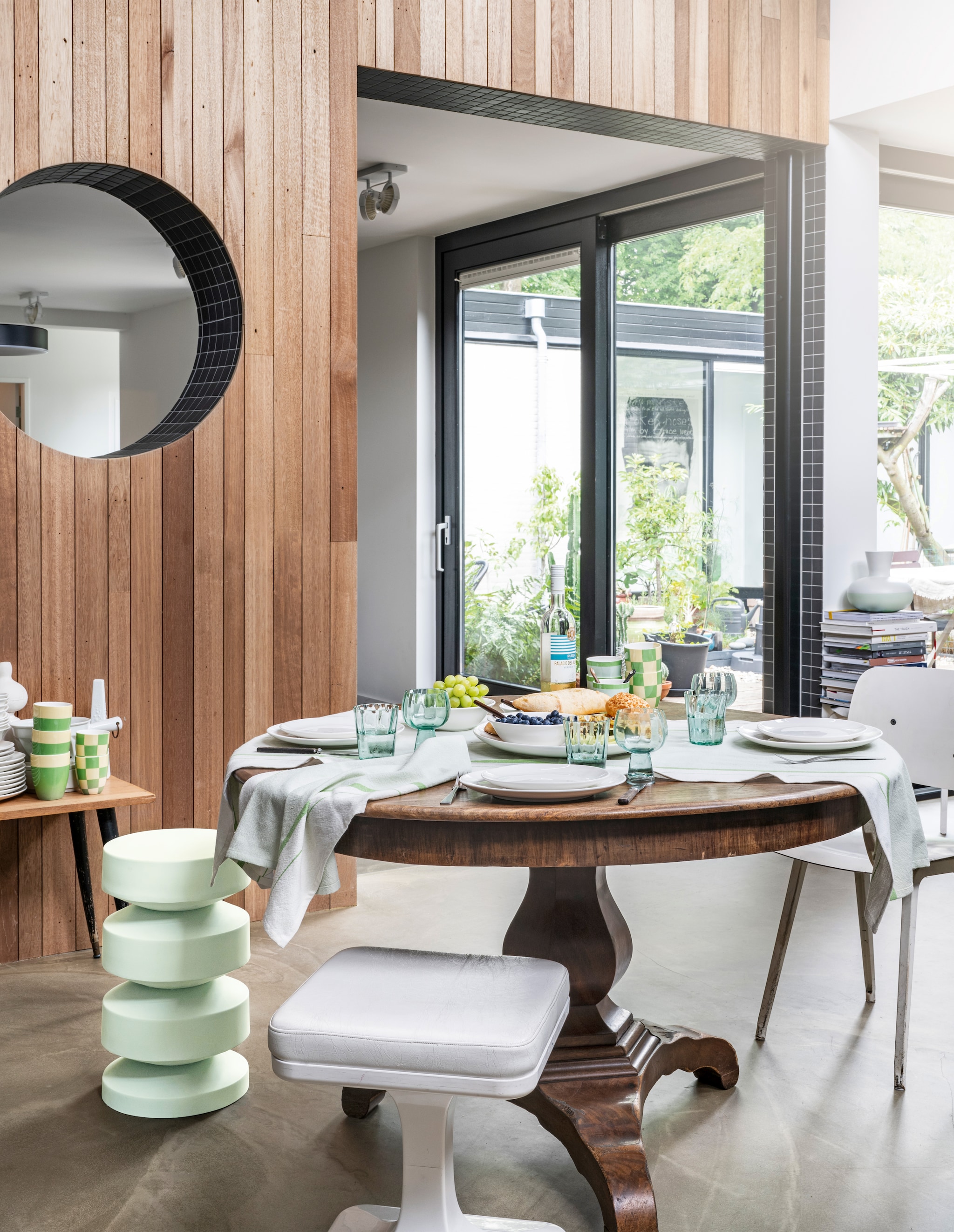 Metalen bijzettafel, 30x50,5 cm (Øxh) € 149,-, porseleinen meerkleurige mokken, diverse maten, set van 3 vanaf € 19,95, waterglazen en wijnglazen, gerecycled glas, diverse maten vanaf € 7,95, theedoeken in groen, katoen en linnen, 50x70 cm, set van 2 € 19,95, porseleinen servies in wit, diverse onderdelen vanaf € 3,50, ook verkrijgbaar als 16-delige set € 89,- en 36-delige set € 199,-. Overig privébezit. vtwonen 04-2024 | styling Tanja Saarberg |  fotografie Stan Koolen