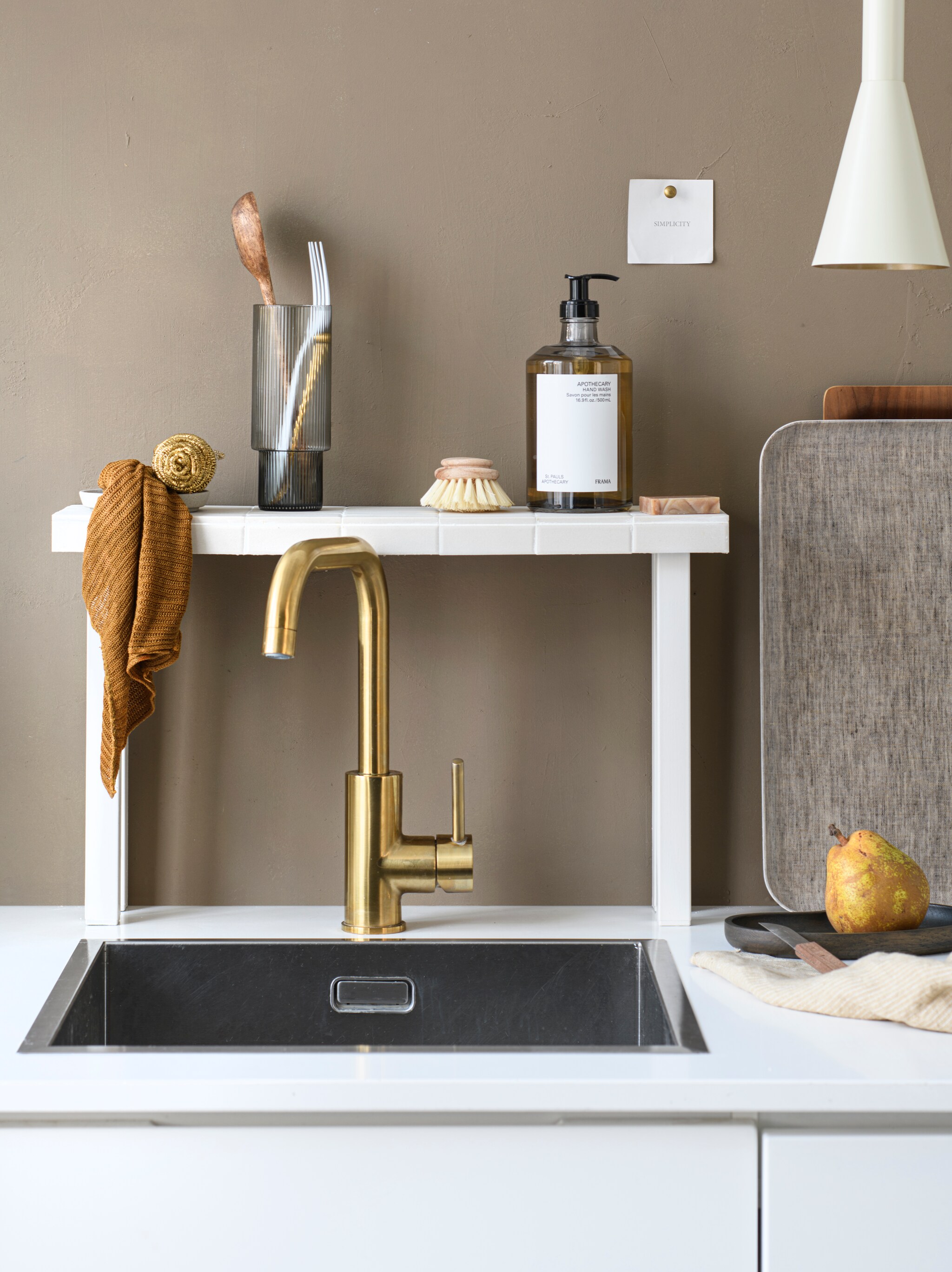 Muurverf 85% Dadel, 2,5 liter € 55,49 (flexa.nl). Longdrinkglas Ripple van Ferm Living in Smoked Grey, set van 4 € 59,-, handzeep in dispenser Apothecary van Frama, 500 ml € 45,-, houten dienblad Walnut Tray van Kinto € 47,-, dienblad Linen Tray Natural van Fog Linen Work € 34,-, linnen theedoek Pinstripe Honey van By Mölle € 15,-, houten schaal Filipine Tray Smoked Oak van Oslo Aula € 49,- (thefinestore.com). Metalen hanglamp Body van BePureHome € 49,95 (basiclabel.nl). Staalspons € 8,-, zeepblok van Helemaal Shea € 7,95 vtwonen 05-2024 DIY | styling Myla Griese | fotografie Louis Lemaire