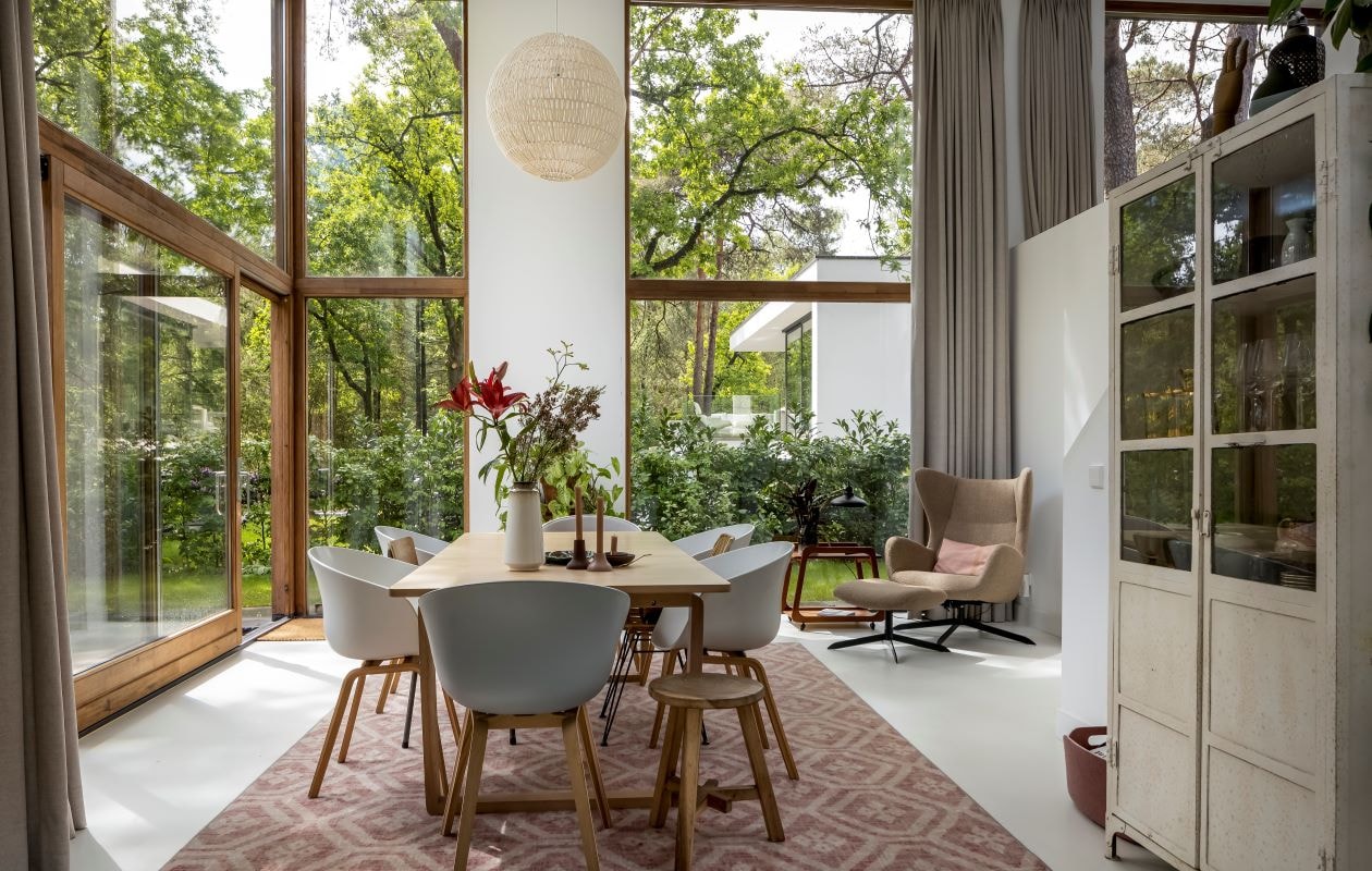 Eettafel Bolia, eetkamerstoelen Hay, vintage schoolstoelen, apothekerskast en kleed van Desso via Marktplaats, kruk Nijhof, vaas Hema, kandelaars cadeau gekregen, schaal herkomst onbekend, lamp Zuiver, houten schildershand Ikea, muurkleur Mild Umber van Flexa. Beeld vtwonen 03-2023 | styling Martine Jeuken | fotografie Henny van Belkom