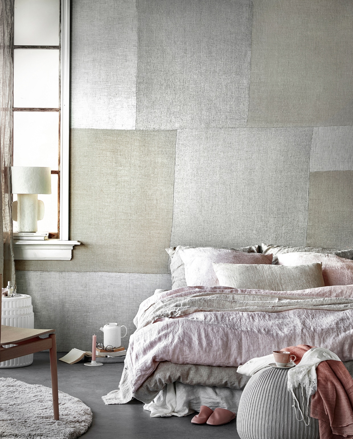 Digitaal behang Patchwork Fabric,6 banen van 280x50 cm, totaal (lxb) 280x300 cm € 149,-.M.m.v. hm.com (linnen gordijnen), paviljoennoord.com (papier-maché lamp, vest, roze shawl, kanten hemdje), kasstoor.nl (wit keramieken bijzettafel, rond vloerkleed), bolia.com (houten stoel, theepot), letoile.store (kandelaar), homestede.nl (betonnen schaal, poef), zara.com (roze kop-en-schotel, roze leren instappers), bymolle.com (wit laken in kleur Pure White, linnen dekbedovertrek in kleur Flax, linnen dekbedovertrek in kleur Blush, linnen plaid in kleur Sea Shell, linnen kussenslopen in kleur Blush en Flax), pure-original.nl (lakverf in kleur Ashes). Overig privébezit. vtwonen 05-2021 | productie Tanja Saarberg | styling Danielle Verheul | fotografie Peggy Janssen