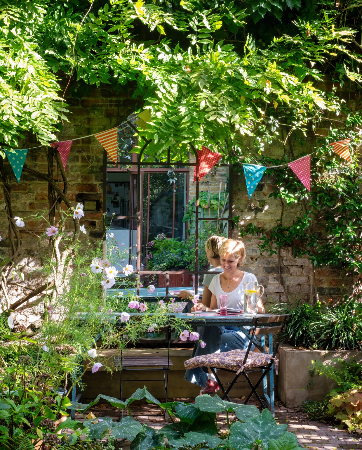 De tuin werd weliswaar kleiner, maar is groener dan ooit. De terrasdeuren liet Charlotte maken op aanwijzingen van Karine. vtwonen special 131-2024 | productie Photofoyer | fotografie Benedicte Drummond | styling Fiona Evans