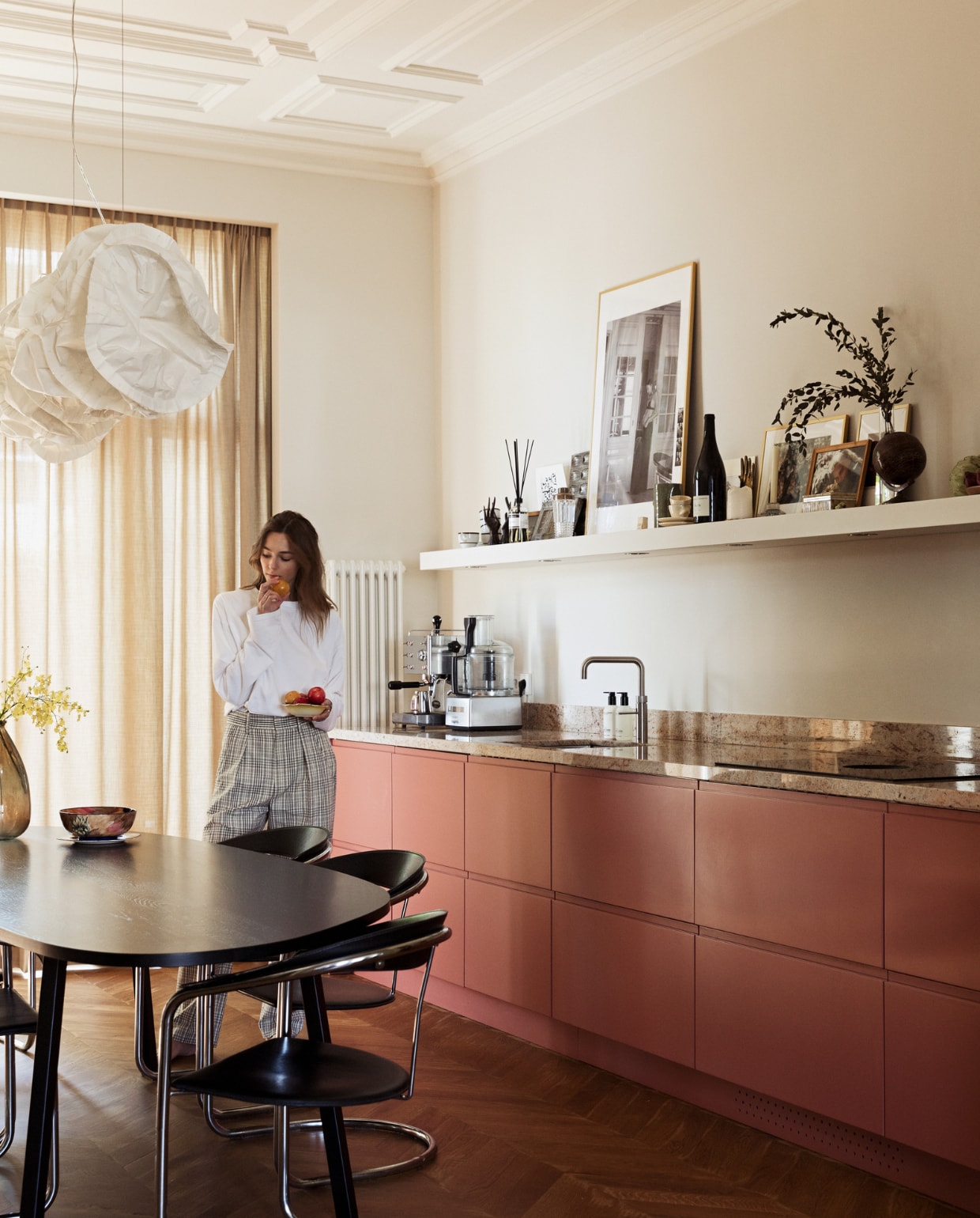 Houten vloer gelegd in Hongaarse punt laminaatenparket.nl. Stoelen en gordijnen Marktplaats. Eettafel Studio Henk. Hanglamp Belux Cloud van Frank Gehry. Keuken basis van Ikea, fronten Frontz. Granieten aanrechtblad De Keukenbladen Fabriek. Kookplaat Bora. Kraan Quooker. Keukenmachine Magimix. Koffiezetapparaat Isomac. Geurstokjes Marie-Stella-Maris. Cocktailshaker erfstuk van Lidians grootouders. Servies van Louks grootouders. Madeleinevorm en Droste chocoladevorm antiekmarkt. Verfkleur achterwand Ral 9001. Verf plafond Ral 9010. Overig onbekend. vtwonen 08-2022 | styling Ilona Jongepier | fotografie Dana van Leeuwen