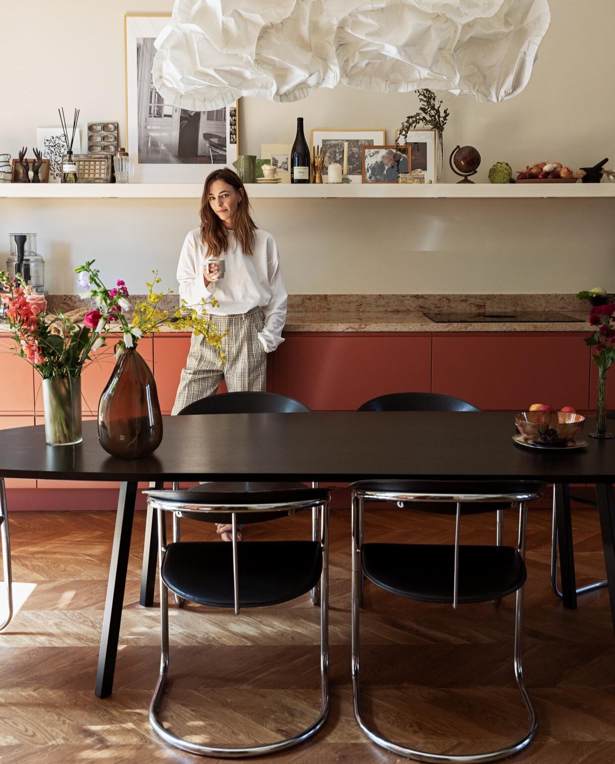 Houten vloer gelegd in Hongaarse punt laminaatenparket.nl. Stoelen en gordijnen Marktplaats. Eettafel Studio Henk. Hanglamp Belux Cloud van Frank Gehry. Keuken basis van Ikea, fronten Frontz. Granieten aanrechtblad De Keukenbladen Fabriek. Kookplaat Bora. Kraan Quooker. Keukenmachine Magimix. Koffiezetapparaat Isomac. Geurstokjes Marie-Stella-Maris. Cocktailshaker erfstuk van Lidians grootouders. Servies van Louks grootouders. Madeleinevorm en Droste chocoladevorm antiekmarkt. Verfkleur achterwand Ral 9001. Verf plafond Ral 9010. Overig onbekend. vtwonen 08-2022 | styling Ilona Jongepier | fotografie Dana van Leeuwen