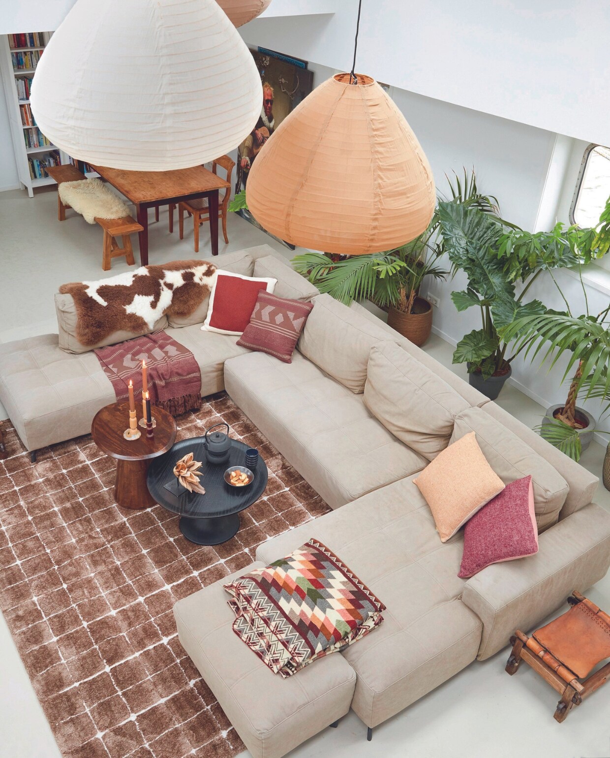 Vloerkleed Blocks van vtwonen, zandcement vloer met betonverf, hanglampen HKliving, boekenkast Ikea, teakhouten eettafel Van Til Interieur. Eetkamerbank en eetkamerstoelen Loods 5. Schapenvacht Texelana, kussens Malagoon, houten bijzettafel uit Uganda, kandelaars Bolia, theepot Simon Lévelt, plaids EcuaFina, bloempotten Mica Decorations. Overig onbekend. vtwonen 03-2024 | styling Marianne Luning | fotografie Tjitske van Leeuwen