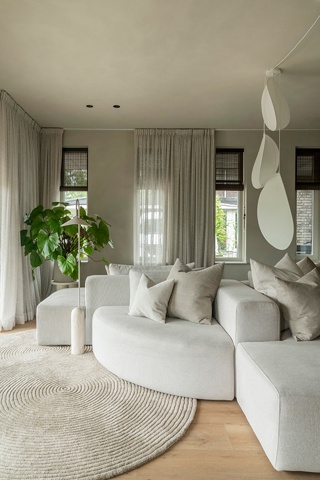 De woonkamer in de uitbouw heeft ramen aan drie kanten. De lampionnenlampen komen van Bolia. De modulaire eilandbank heeft zowel ronde als geometrische elementen en is van 4x6 Sofa. Fotografie Muk van Lil