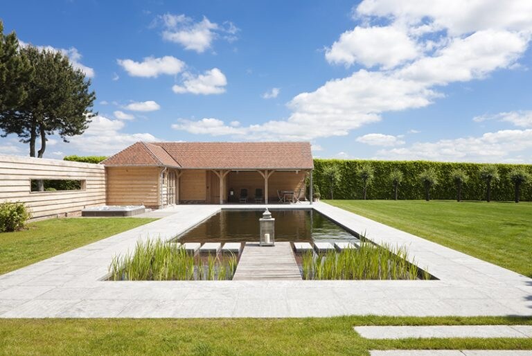 Strak maar toch warm, dat was de wens die de bewoners hadden. En die wens werd dankzij de zwemvijver en het poolhouse ruimschoots ingewilligd. Cools Zwemvijvers &amp; Tuinaanleg