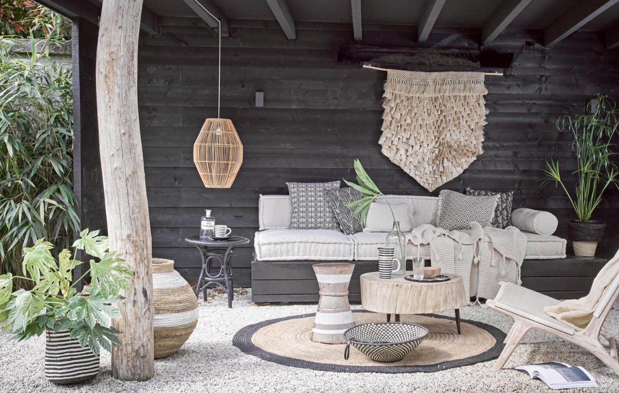 Loungekussens 80x80x15 cm € 195,-, rugkussen 120x30x15 cm € 160,-, rolkussenhoes € 35,-, ecru kussen 50x50 cm € 29,- (Household Hardware). Wandkleed € 295,-, houten buitenstoel € 699,-, hoge gevlochten pot met witte band vanaf € 82,-, houten bijzettafel met witte bies vanaf € 320,-, grote houten tafel € 599,-, lage schaal in zwart-wit € 89,-, hanglamp € 175,-, zwart-wit gestreepte mand vanaf € 47,-, gevlochten pot met zwarte rand € 69,-, ecru plaid Kaldi op stoel € 199,- (Couleur Locale). Gebreide deken € 99,50, vloerkleed rond Ø 180 cm € 175,- (Madam Stoltz). Emaillen dienblad € 27,- (WolfWare). Hoge gestreepte kan € 49,50, gestreepte beker € 15,95 (Maison NL). Houten kom € 9,95 (HK Living). Glas € 6,90 (Six and Sons). Oude apothekersfles € 29,- (De Weldaad). Glazen fles € 30,- (Burbri Antiek). Zwarte bijzettafel € 125,- (All the Luck in the World). Gedessineerde kussenhoes links € 4,99, kussenhoes met zwarte bladeren € 9,99, kussenhoes met rafels en grafisch dessin € 14,99, zwarte kussenhoes met witte blaadjes € 4,99 (H&amp;M Home). vtwonen 08-2017 | styling Cleo Scheulderman | fotografie Alexander van Berge