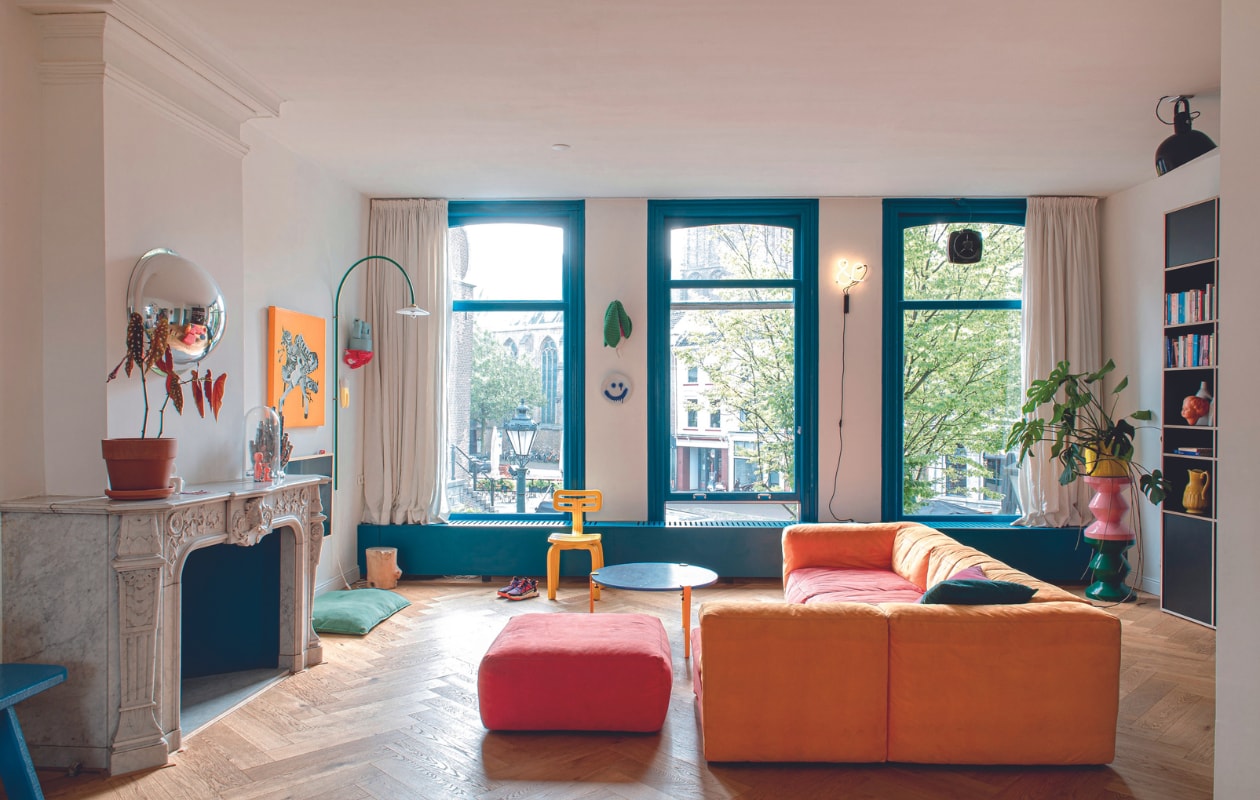 Bank Hay, salontafel Tiptoe, systeemkast Tylko, plafondlamp rommelmarkt, opgestapelde krukken Polspotten, plantenpot erop Serax, gele stoel Dirk van der Kooij, gehaakte radijs Anne-Claire Petit. Smileybord en bolspiegel The Dirt. Booglamp Muller Van Severen, oranje kunstwerk Boxie, rode wandplank studio Thier &amp; van Daalen, pot van Hanna Kooistra, verf kozijnen Piet Hein Eek Project Blue 03 van Lacq. Overig onbekend. vtwonen 04-2024 | productie De Binnenkijkers | styling Jeske Weel | fotografie Caroline Coehorst