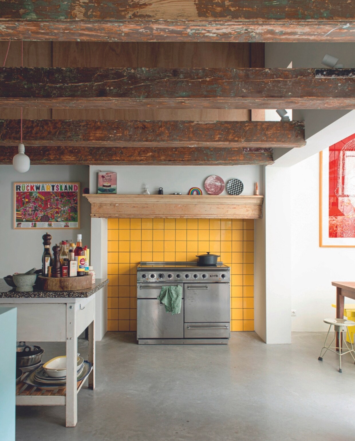 Oven Falcon, gele wandtegels Mosa, borden op schouw gemaakt door de kinderen, zeefdruk links Henning Wagenbreth, oude bakkerstafel Van Dijk &amp; Ko. vtwonen 04-2023 | productie De Binnenkijkers | styling Jeske Weel | fotografie Caroline Coehorst