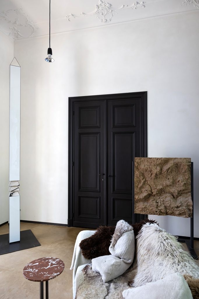 Dubbele zwarte deur en sofa met pels in design en kunst herenhuis Kaatje Verschoren