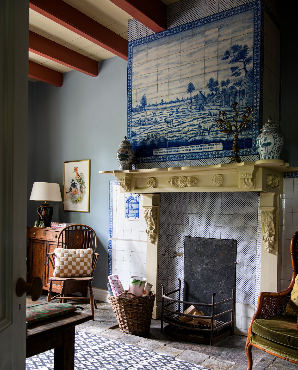 Schouw en tegels origineel. Kastje en stoel uit de familie. Poster: Heliomaster Angelae print door J. Gould, H. Richter en C. Hullmandel. Draakjes, lamp, vaas en groene fauteuil Marktplaats. Plinten Plintenfabriek. Geblokt kussen HKliving. Kleed Mrs Bloom. Vazen schouw kringloop. Kandelaar Catawiki. Muurverf Nordic Lake, houtlak balken Copperhead, beide van Lab Paint. Overig onbekend. vtwonen binnenkijken special 131-2024 | productie Inside Homepage | styling Kim Timmerman | fotografie Louis Lemair