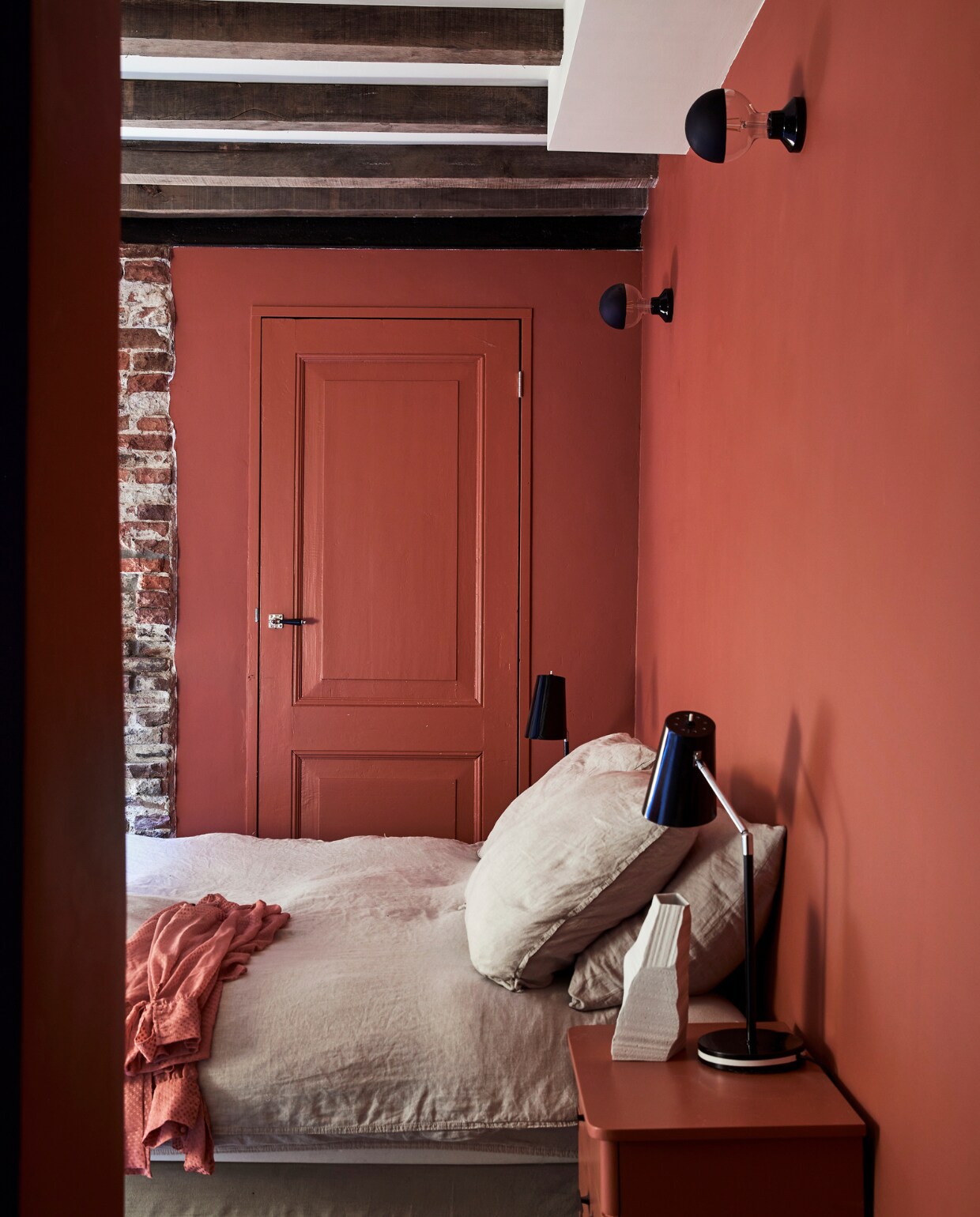 Verfkleur Picture Gallery Red van Farrow &amp; Ball. Nachtkastjes gekregen van vriendin. Bedlampen tweedehands uit Spanje. Witte vaas Klaas Kuiken. Overig onbekend. vtwonen special binnenkijken 03-2022 | Fotografie Peggy Janssen