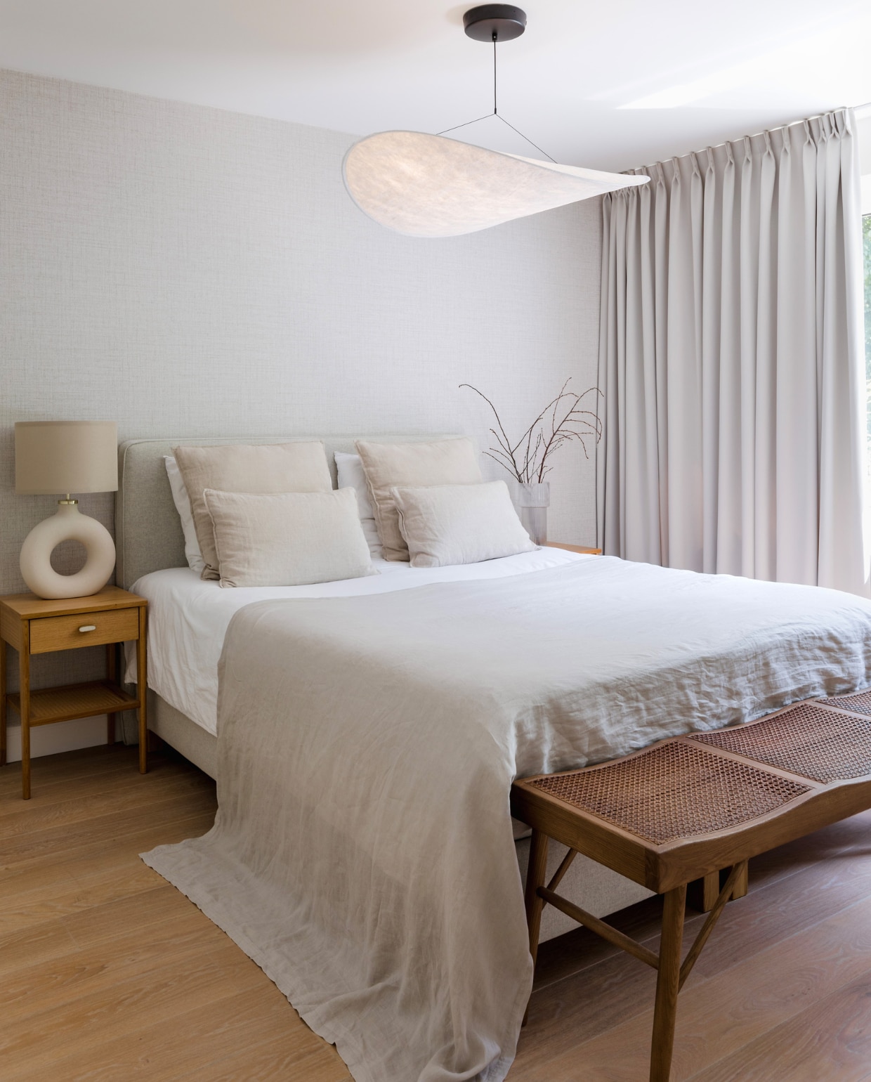 Behang Puro 27000 van Arte, boxspring Ikea, hanglamp New Works van Tense via Lampen Master. Nachtkastjes Jysk, grepen Zara Home. Lamp op nachtkastje, bedlinnen en vaas met takken H&M Home. Bank Zara Home. vtwonen binnenkijken special 131-2024 | fotografie Corine Hoge Bavel-Jansen