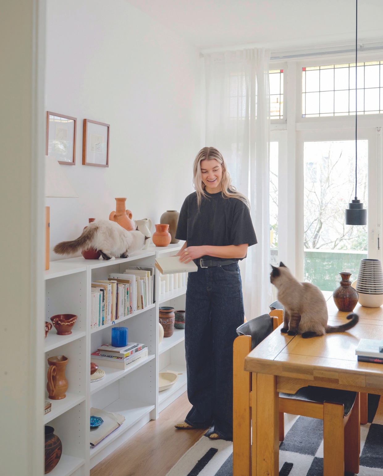 Eettafel vintage, tuigleren stoelen Ibisco, vloerkleed Fést, boekenkast Ikea, hanglamp Zuiver. Aardewerk uit Spanje, Italië en kringloop-winkels. Kunstwerken gekregen. Overig onbekend. vtwonen 05-2024 | fotografie Mr. Frank