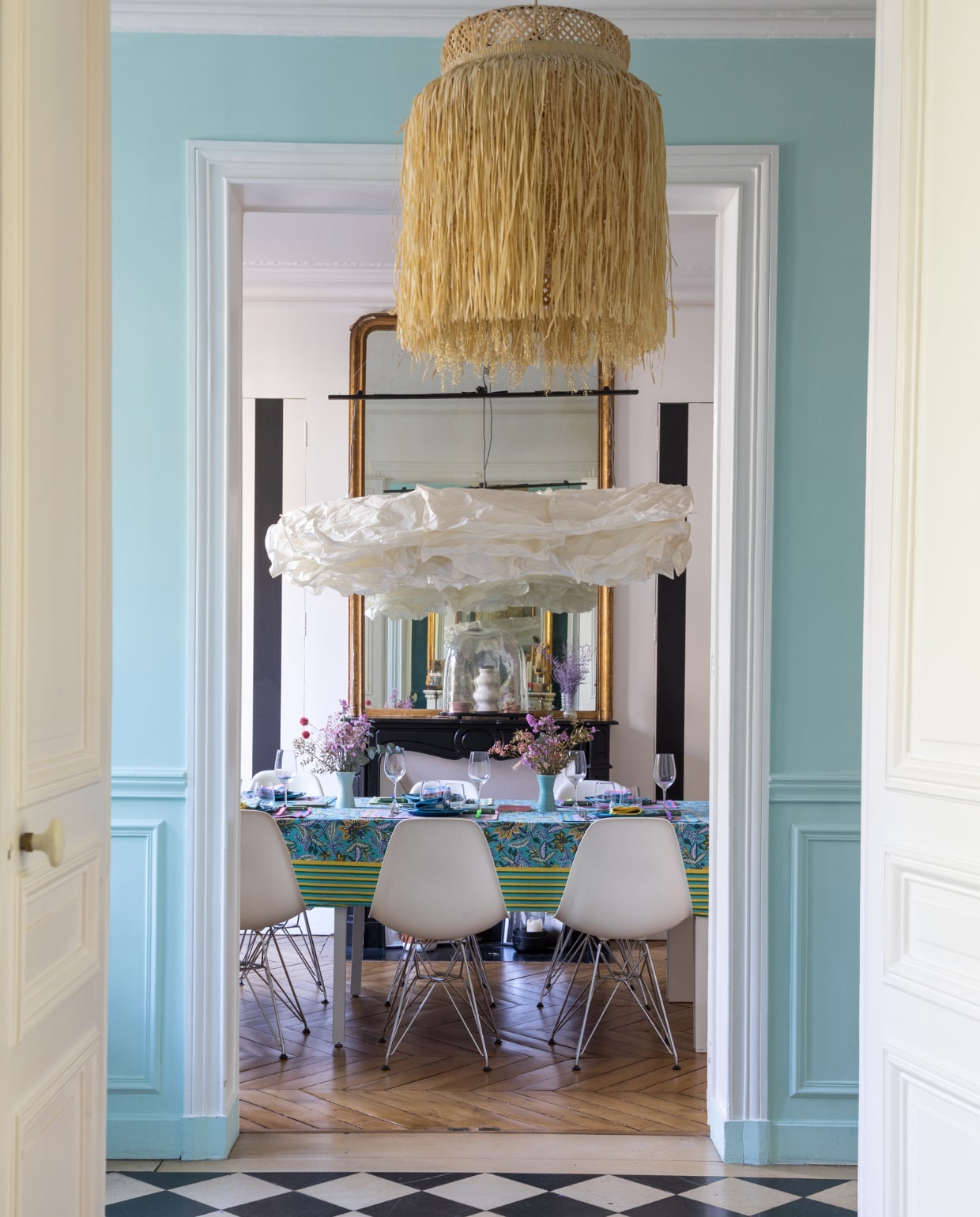 Eames-stoelen Vitra, tafellinnen Caroline de Benoist, lampen Ikea en DIY, borden erfstuk, vaasjes Søstrene Grene, behang Leroy Merlin. Verfkleur Delicate Blue van Little Greene. Overig onbekend. vtwonen binnenkijken special 131-2024 | productie Marie Maud Levron Creations | fotografie Cécile Perrinet Lhermitte