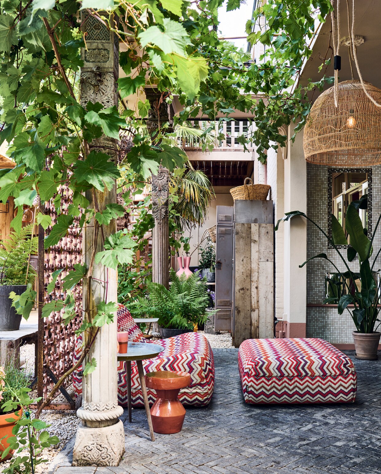 De veranda bij het huis is net een Marokkaanse binnenplaats. Ertegenaan klimmen een druif en klimroos. De pilaren stonden er al. Outdoor loungebank met hocker Muna met stof Fiesta van evavandeven.nl. Keramieken bijzettafel Urban Nature Culture, bijzettafel op poten Kwantum, witte bijzettafel Karwei. Kandelaar en mand Household Hardware. Hanglamp en mok HKliving. vtwonen tuinspecial 10 | styling Liza wassenaar | fotografie Sjoerd Eickmans