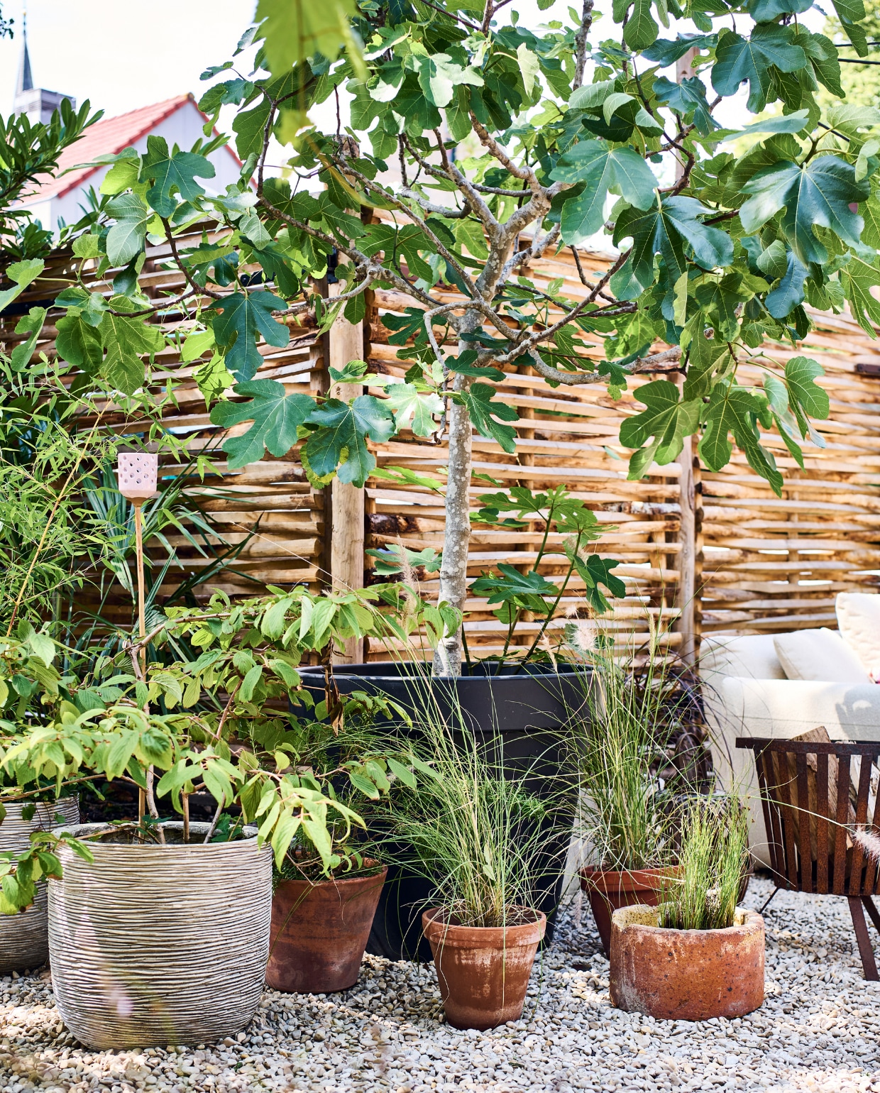 Potten van onder andere Intratuin, met Yucca rostrata, lampenpoetsersgras, varen en Nieuw Zeelands vlas. Bamboe buitenlamp Kwantum. vtwonen tuinspecial 10 | styling Liza wassenaar | fotografie Sjoerd Eickmans
